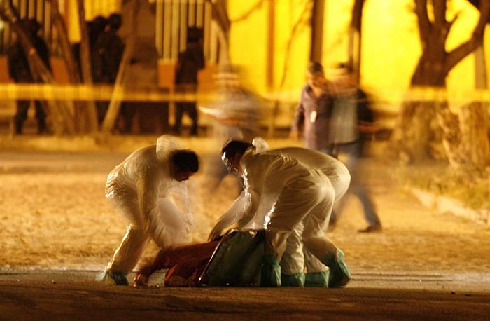 Forensic personnel remove the body of one of Garcia's security secretary Juan Arturo Esparza Garcia's bodyguards from a crime scene in the municipality of Garcia, on the outskirts of Monterrey November 4, 2009. Following a series of threats on the life of Garcia's Mayor Jaime Rodriguez Calderon by drug cartels, 30 gunmen attacked a truck transporting Esparza Garcia, a retired brigadier general who was working as a security secretary for the municipality, killing him and four of his bodyguards, local media reported. REUTERS/Tomas Bravo (MEXICO CONFLICT SOCIETY MILITARY)