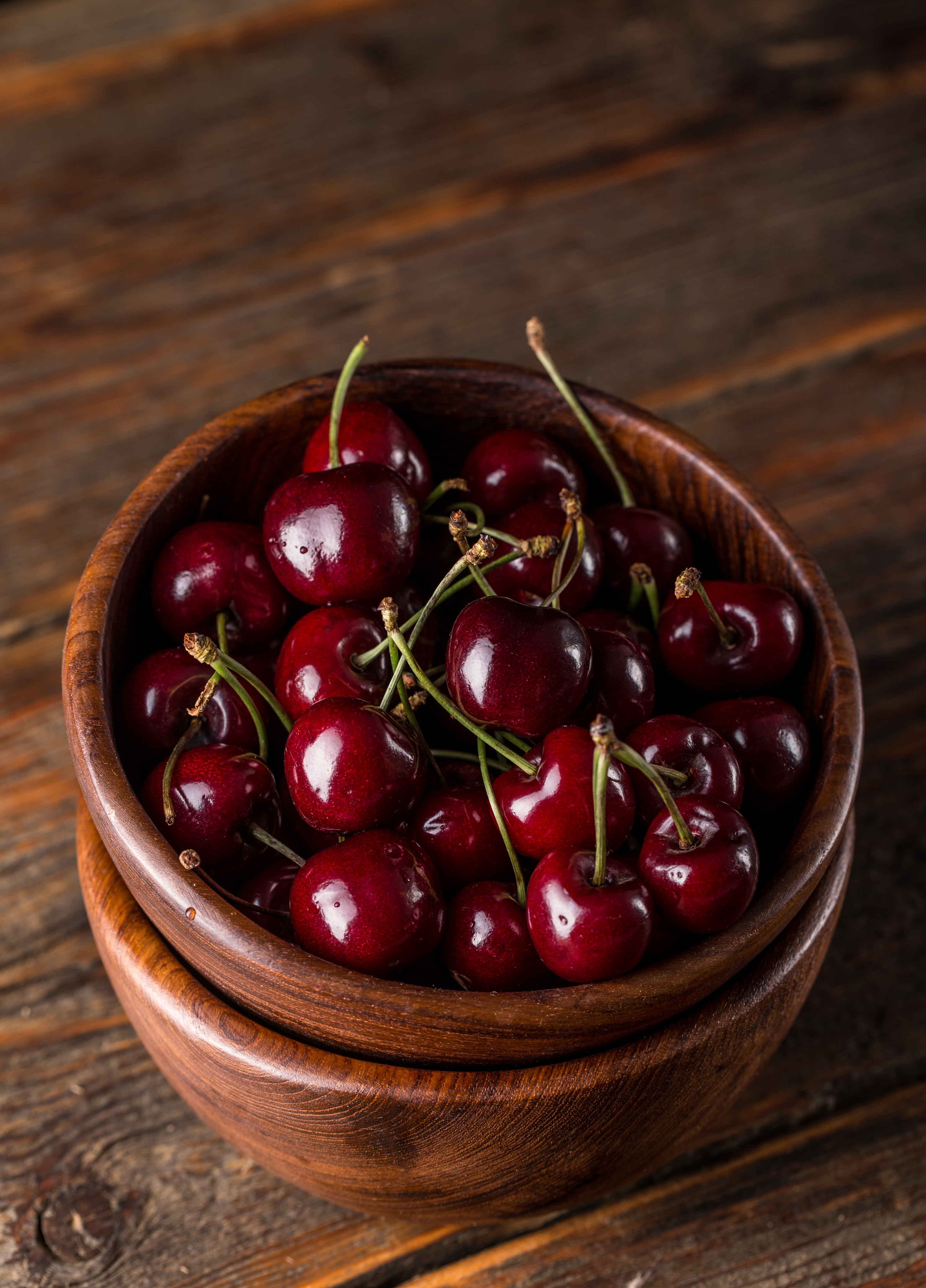 Sour cherry in bowl on wooden background