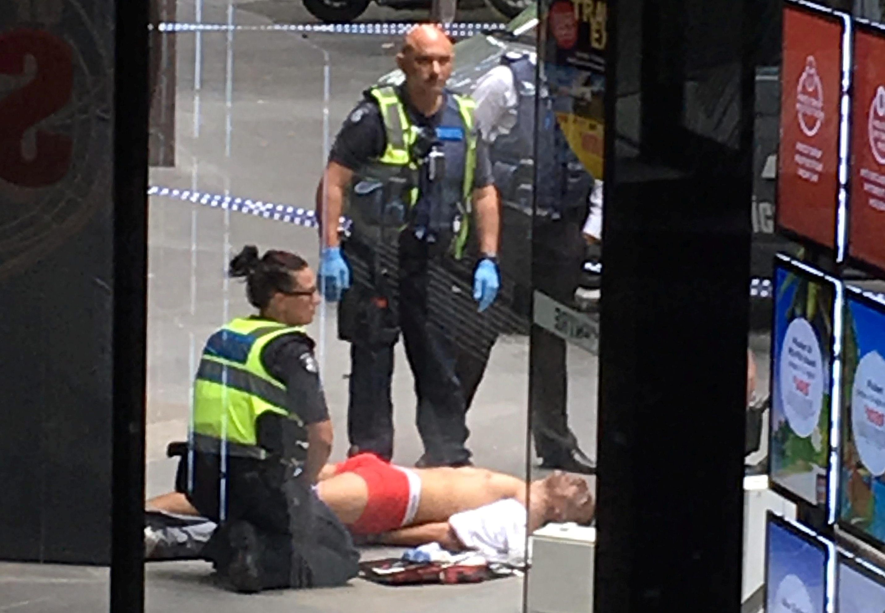 Police and medical staff surround a man as he lies on the footpath after a car hit pedestrians in central Melbourne, Australia, January 20, 2017. AAP/AAP Image/via REUTERS ATTENTION EDITORS - THIS IMAGE WAS PROVIDED BY A THIRD PARTY. EDITORIAL USE ONLY. NO RESALES. NO ARCHIVE. AUSTRALIA OUT. NEW ZEALAND OUT. TPX IMAGES OF THE DAY