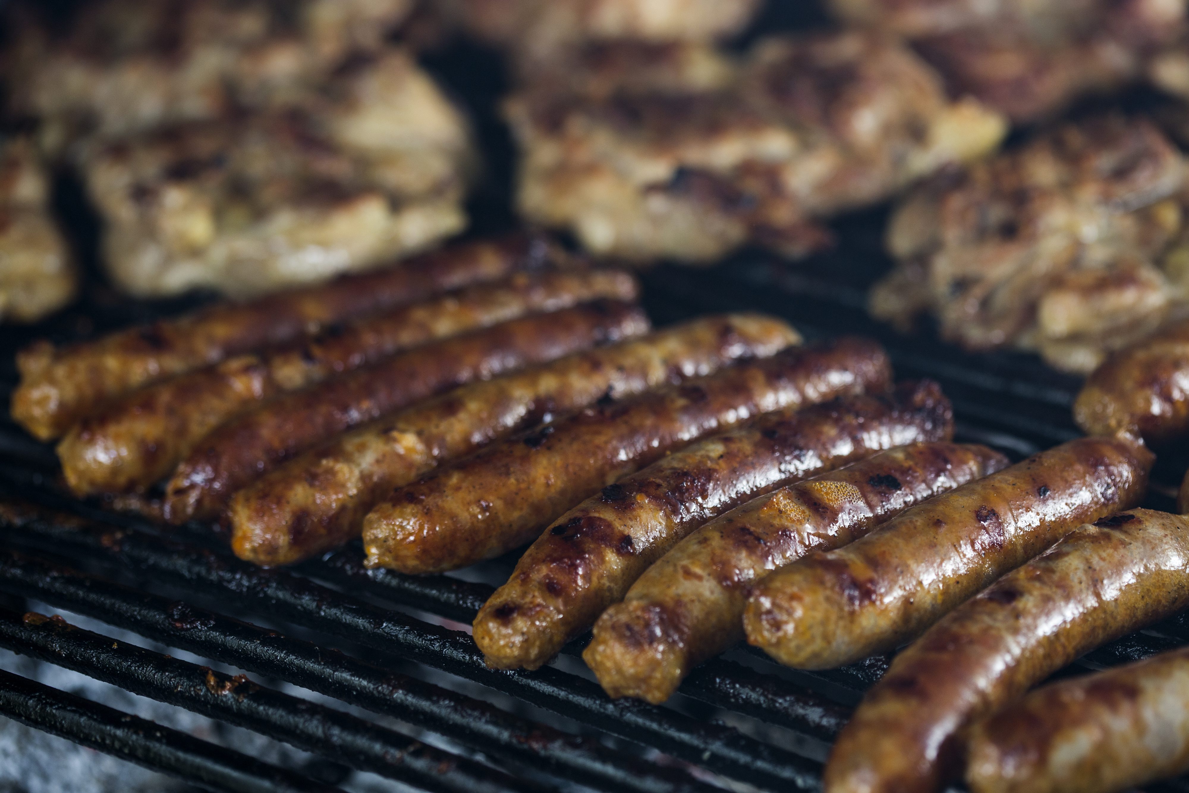 Makarska,160817.
Trubac Stipe Madjor Bozinovic priprema  rostilj i salsu od pomidora za prijatelje iz grupe Pavel i Vatra i clanove njihove obitelji.
Na fotografiji: Kobasice i piletina na gradelama.
Foto: Bozidar Vukicevic / CROPIX