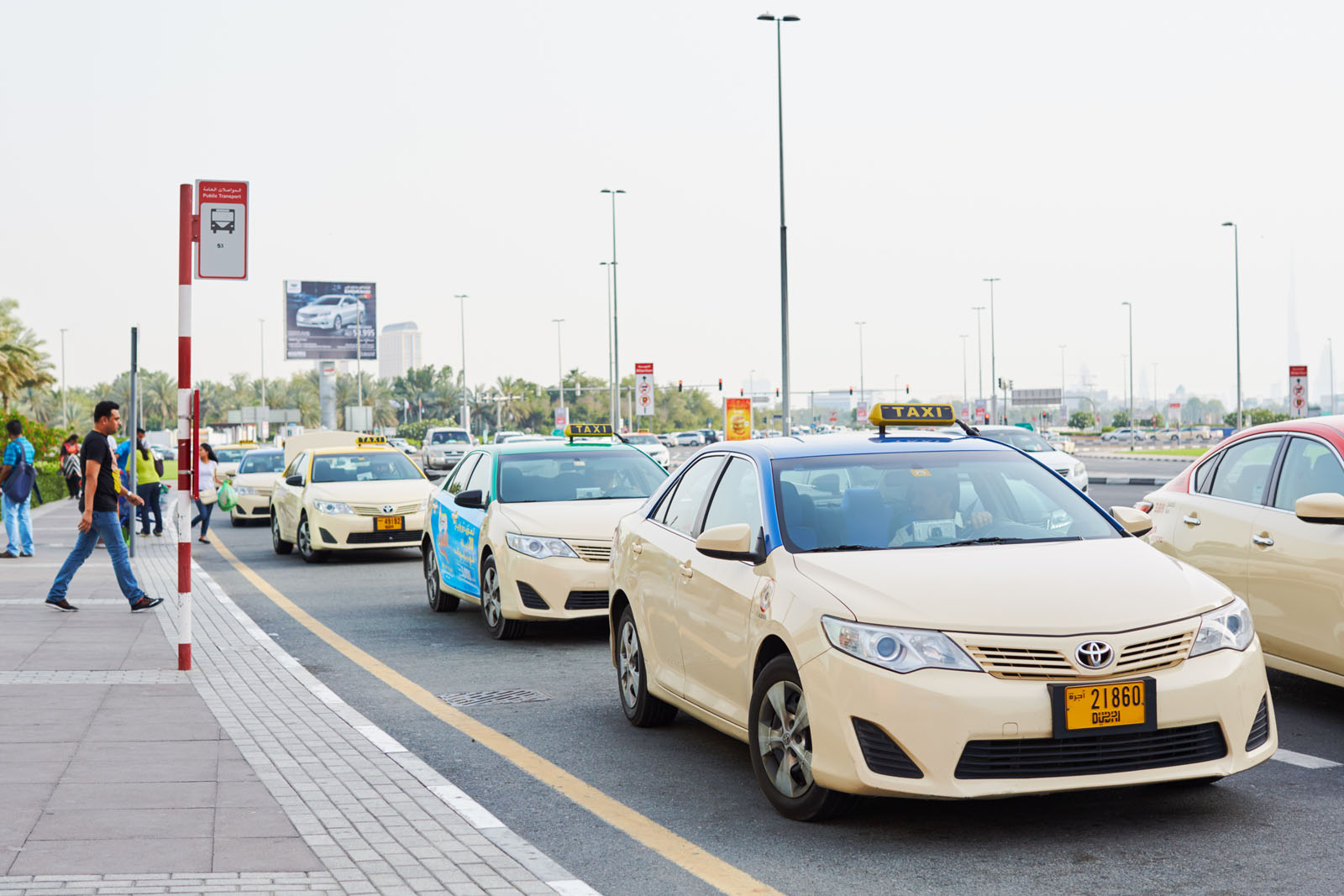 Dubai, United Arab Emirates - May 6, 2016: Blue and red top taxis at Deira City Centre.The Cars Taxis Corporation operates cream-coloured blue roof taxis and Dubai Taxi Corporation operates cream-coloured red roof taxis.The meter generally begins as Dhs. 12.00 when a requesting a cab from the call center, and 5.00 Dhs. when taking a taxi on the road and is generally charged by distance at 1.5 Dhs./km. There are approximately 7900 taxis located in the city.