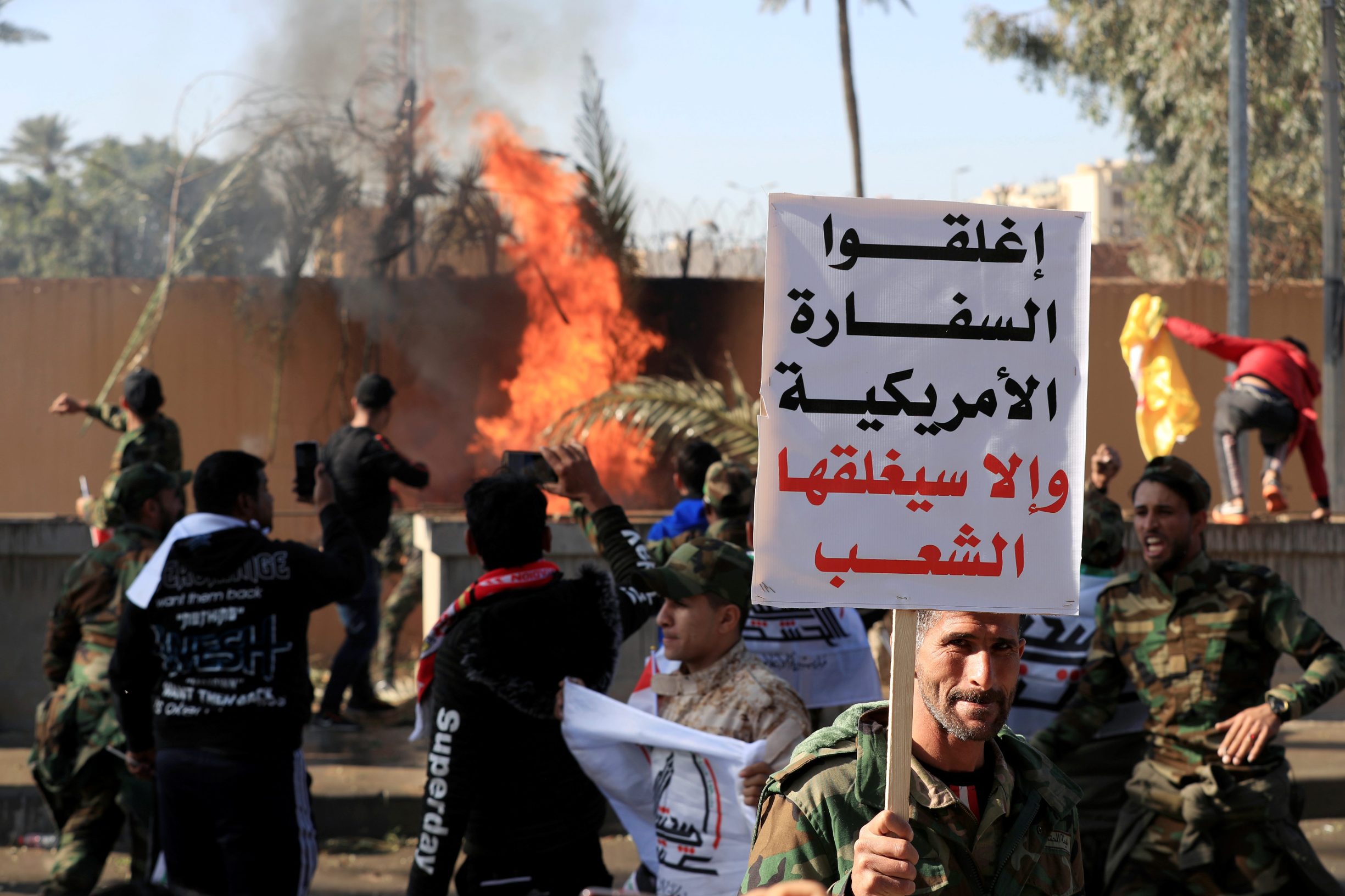 A Hashd al-Shaabi fighter holds a sign reading 