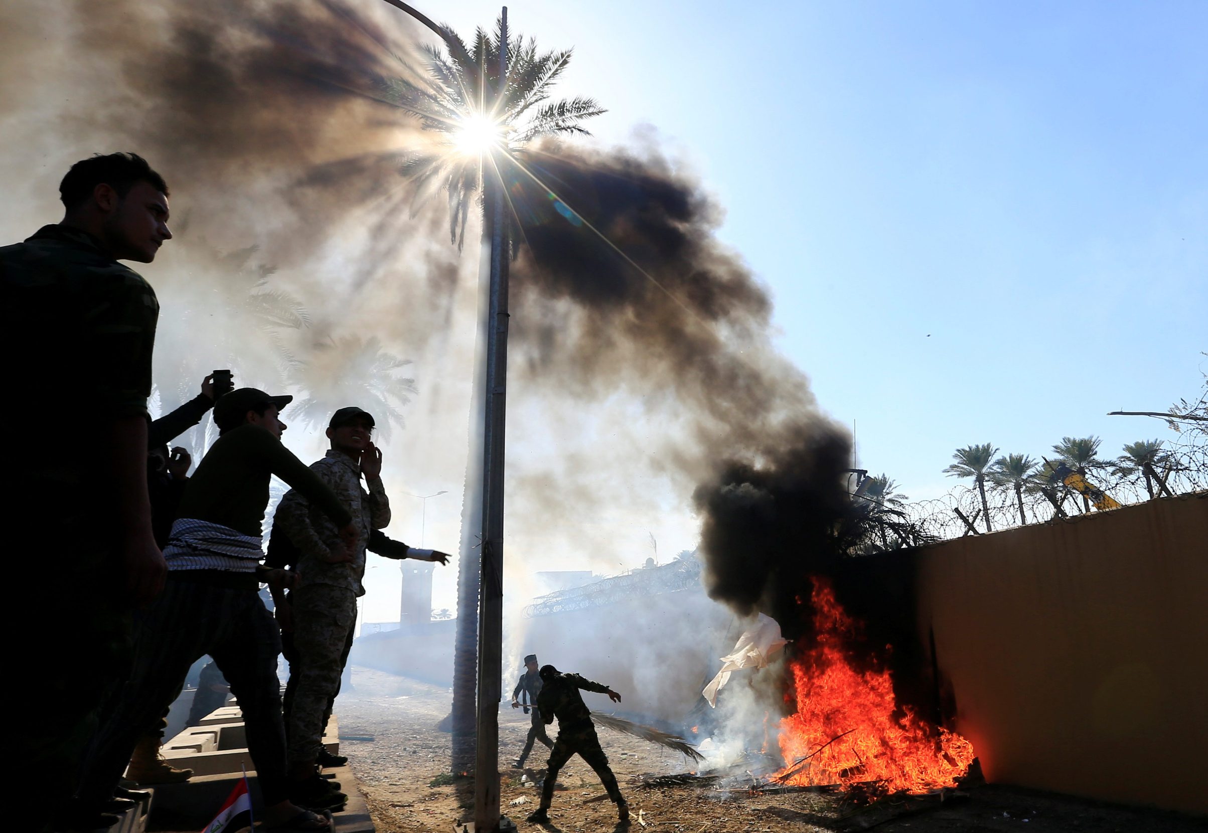 Hashd al-Shaabi (paramilitary forces) fighters set fire on the U.S. Embassy wall to condemn air strikes on their bases, in Baghdad, Iraq December 31, 2019. REUTERS/Thaier al-Sudani