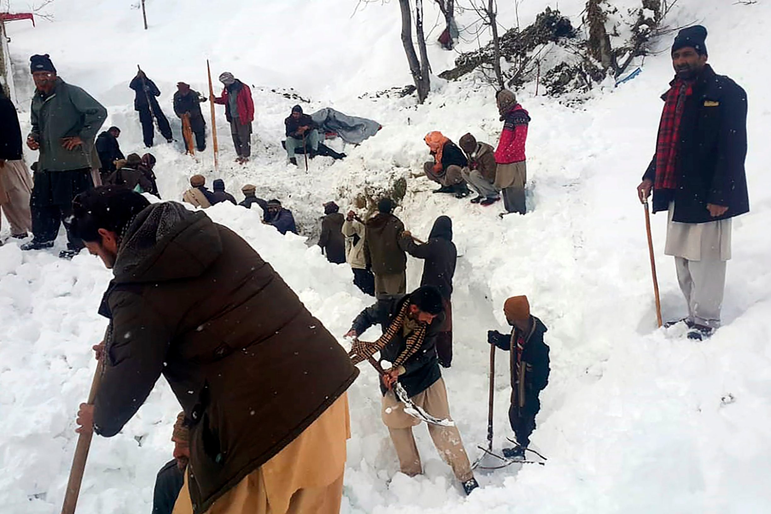 Local residents search for the avalanche victims in the snow in Neelum Valley, in Pakistan-administered Kashmir on January 15, 2020. - Avalanches, flooding and harsh winter weather killed more than 130 people across Pakistan and Afghanistan in recent days, leaving others stranded by heavy snowfall, officials said on January 14. (Photo by STR / AFP)