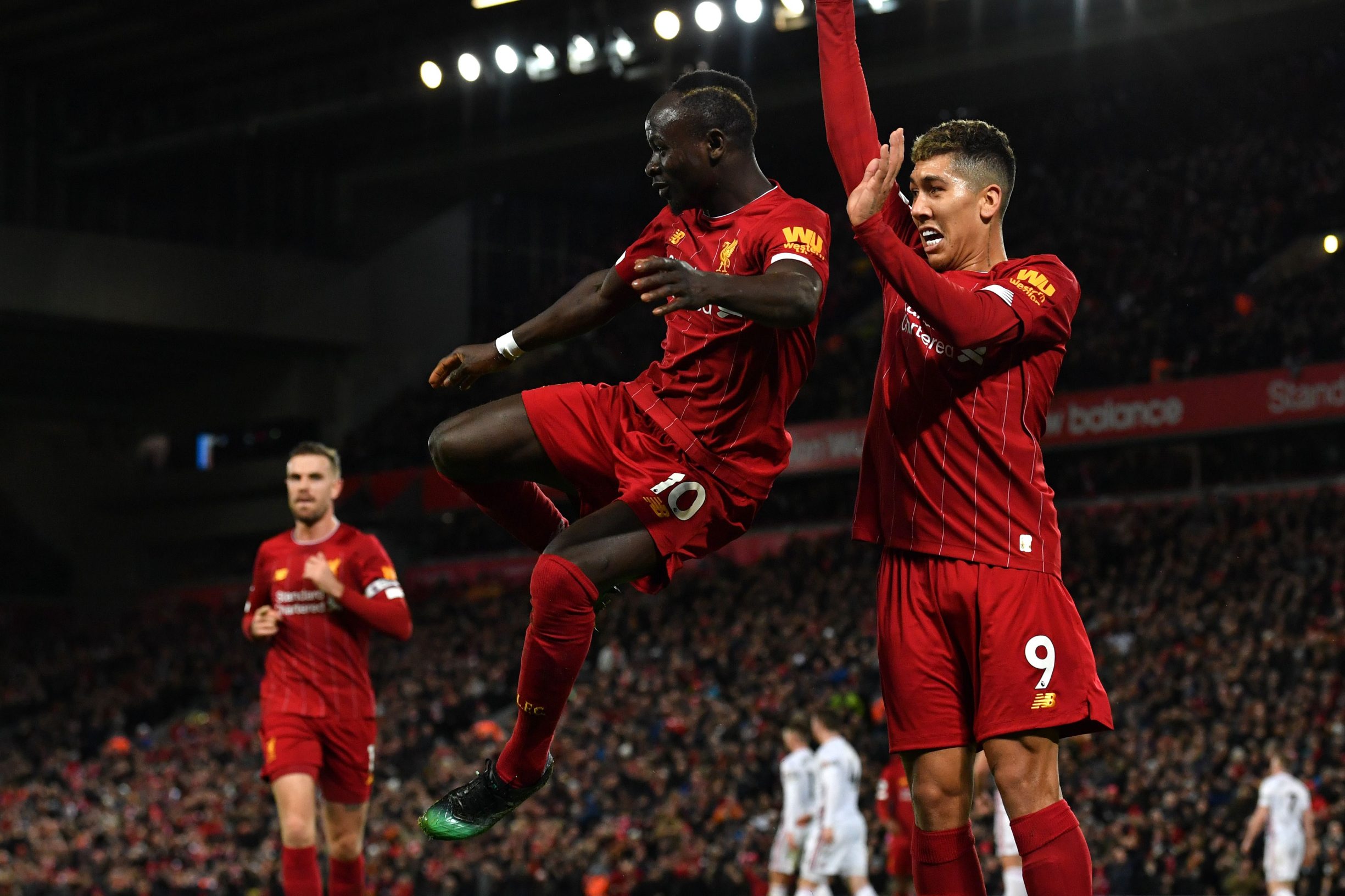 Liverpool's Senegalese striker Sadio Mane (L) celebrates with Liverpool's Brazilian midfielder Roberto Firmino after he scores his team's second goal during the English Premier League football match between Liverpool and Sheffield United at Anfield in Liverpool, north west England on January 2, 2020. (Photo by Paul ELLIS / AFP) / RESTRICTED TO EDITORIAL USE. No use with unauthorized audio, video, data, fixture lists, club/league logos or 'live' services. Online in-match use limited to 120 images. An additional 40 images may be used in extra time. No video emulation. Social media in-match use limited to 120 images. An additional 40 images may be used in extra time. No use in betting publications, games or single club/league/player publications. / 