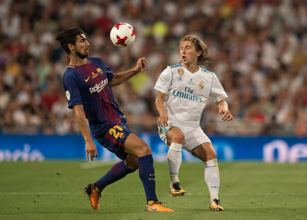 MADRID, SPAIN - AUGUST 16: Luka Modric of Real Madrid CF lobs the ball over the head of Andre Gomes of FC Barcelona during the Supercopa de Espana Final 2nd Leg match between Real Madrid and FC Barcelona at Estadio Santiago Bernabeu on August 16, 2017 in Madrid, Spain. (Photo by Denis Doyle/Getty Images)