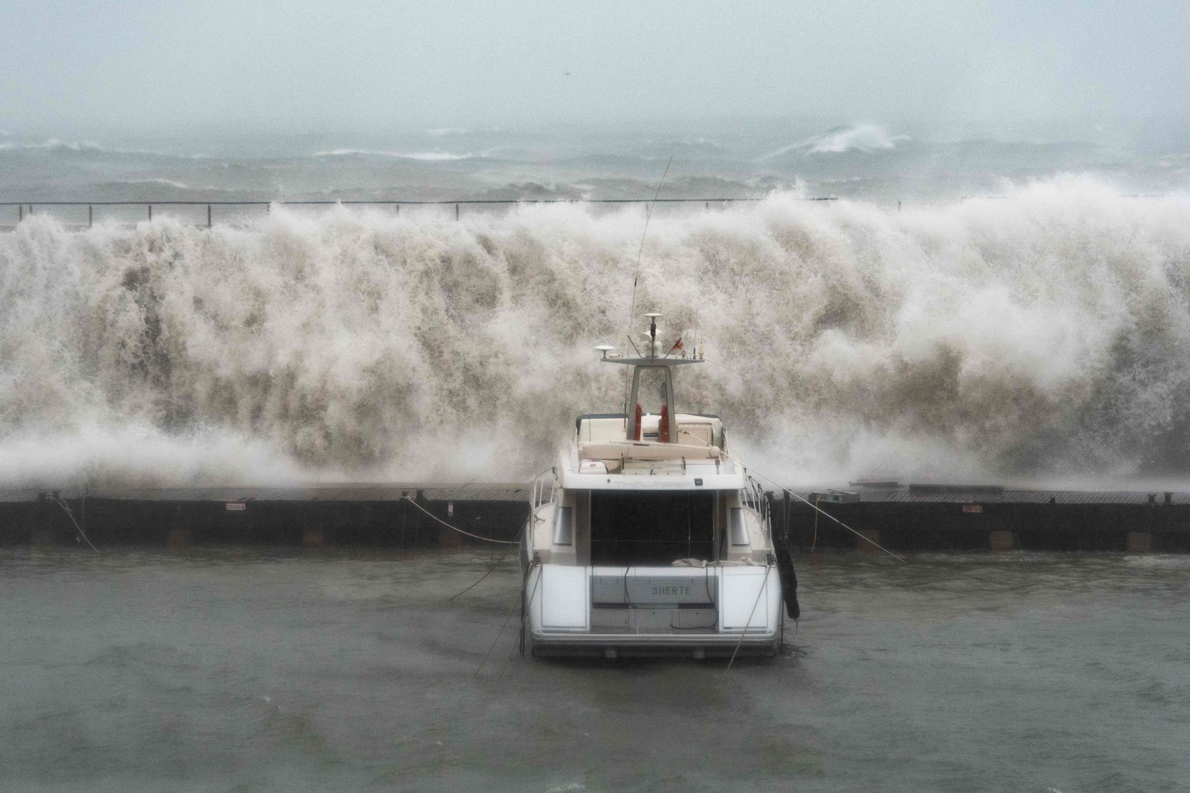 TOPSHOT - Big waves overpass a breakwater at the Port Olympic marina in Barcelona as storm Gloria batters Spanish eastern coast on January 21, 2020. - Freezing winds, heavy snow and rain lashed parts of Spain yesterday, killing three people, forcing the closure of schools that cancelled classes for nearly 200,000 students and disrupting travel, officials said. (Photo by Josep LAGO / AFP)