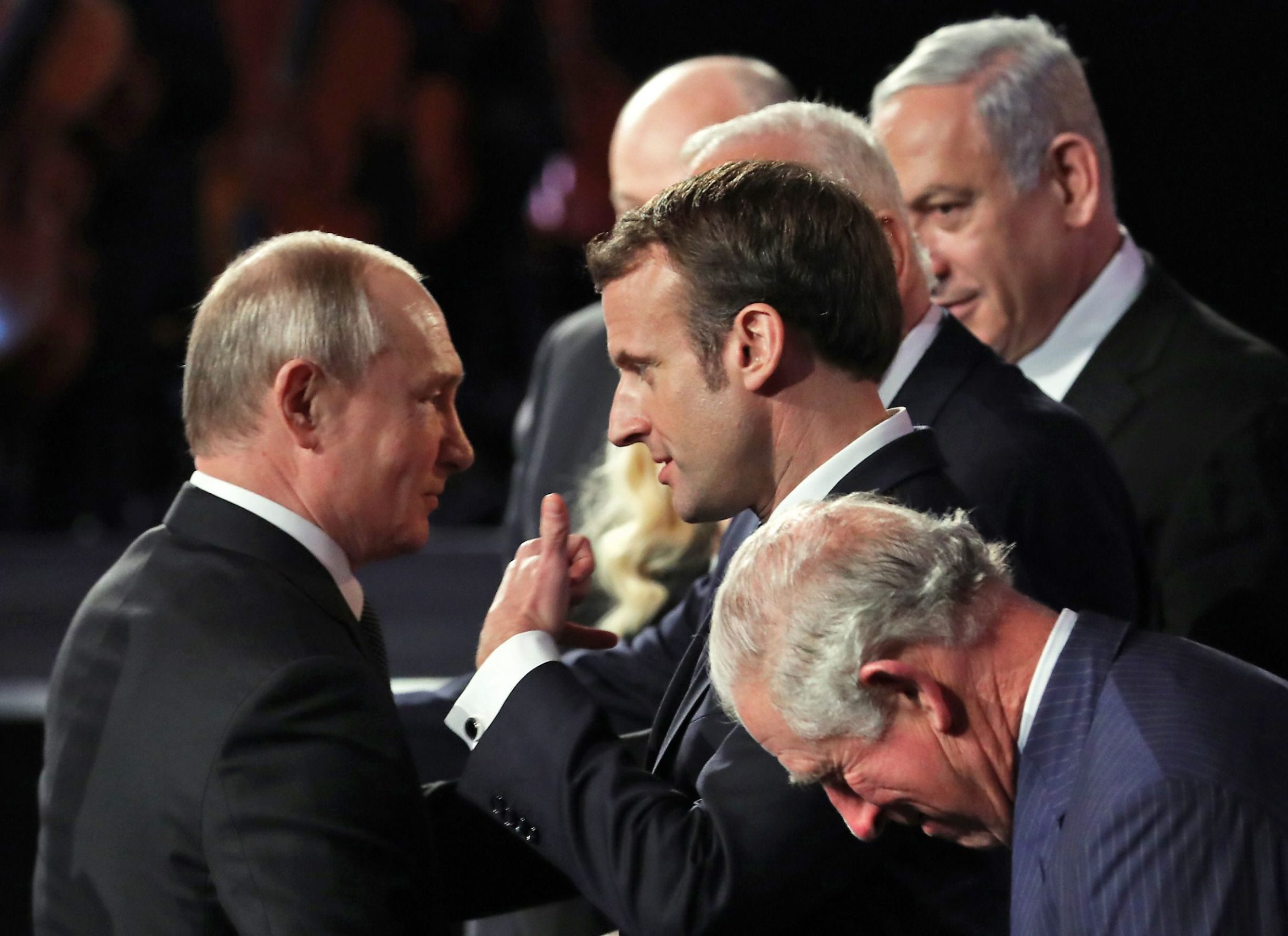 Russian President Vladimir Putin (L) speaks with French Prsident Emmanuel Macron (C) as Britain's Prince Charles (C-down) looks on during the Fifth World Holocaust Forum at the Yad Vashem Holocaust memorial museum in Jerusalem on January 23, 2020. - World leaders travelled to Israel this week to mark 75 years since the Red Army liberated Auschwitz, the extermination camp where the Nazis killed over a million Jews. (Photo by Abir SULTAN / POOL / AFP)