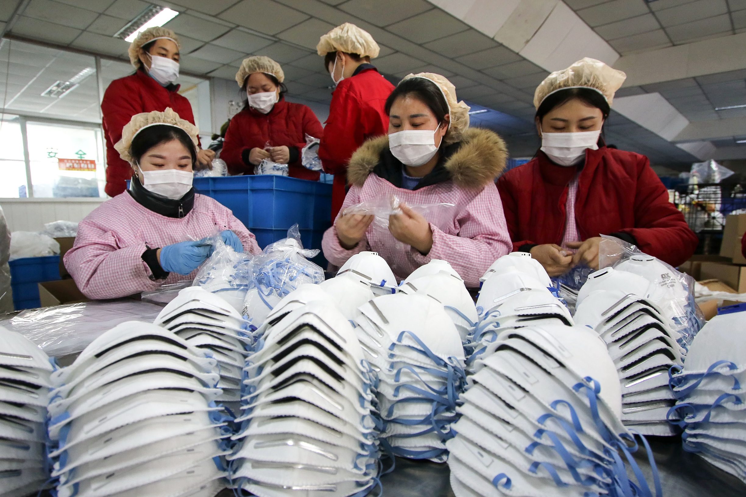 This photo taken on January 22, 2020 shows workers producing facemasks at a factory in Handan in China's northern Hebei province. - China banned trains and planes from leaving Wuhan at the centre of a virus outbreak on January 23, seeking to seal off its 11 million people to contain the contagious disease that has claimed 17 lives, infected hundreds and spread to other countries. (Photo by STR / AFP) / China OUT