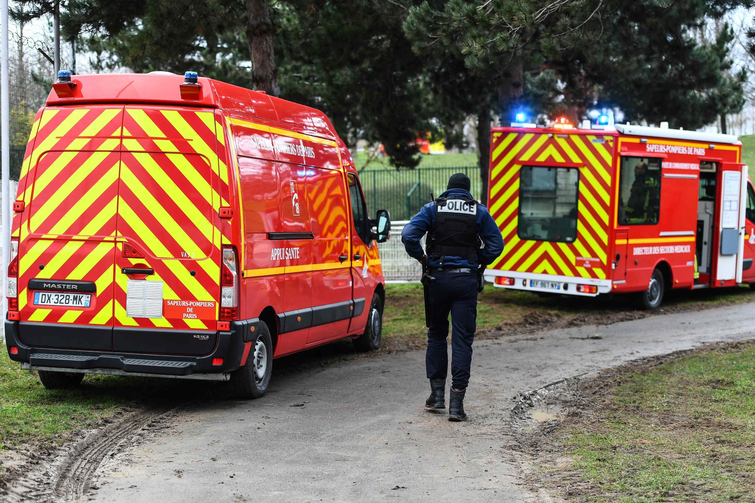 A policeman walks by firefighters vehicles in a park in the south of Paris' suburban city of Villejuif on January 3, 2020 where a man was shot and killed by officers after stabbing passers-by. - The man had attacked 