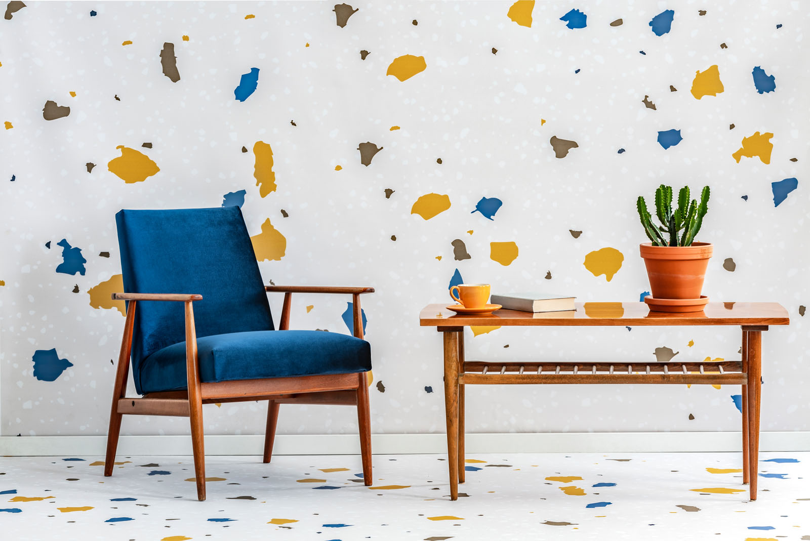Mid-century modern, navy blue armchair and a retro wooden table in a white living room interior with lastrico pattern on the wall and floor. Real photo.