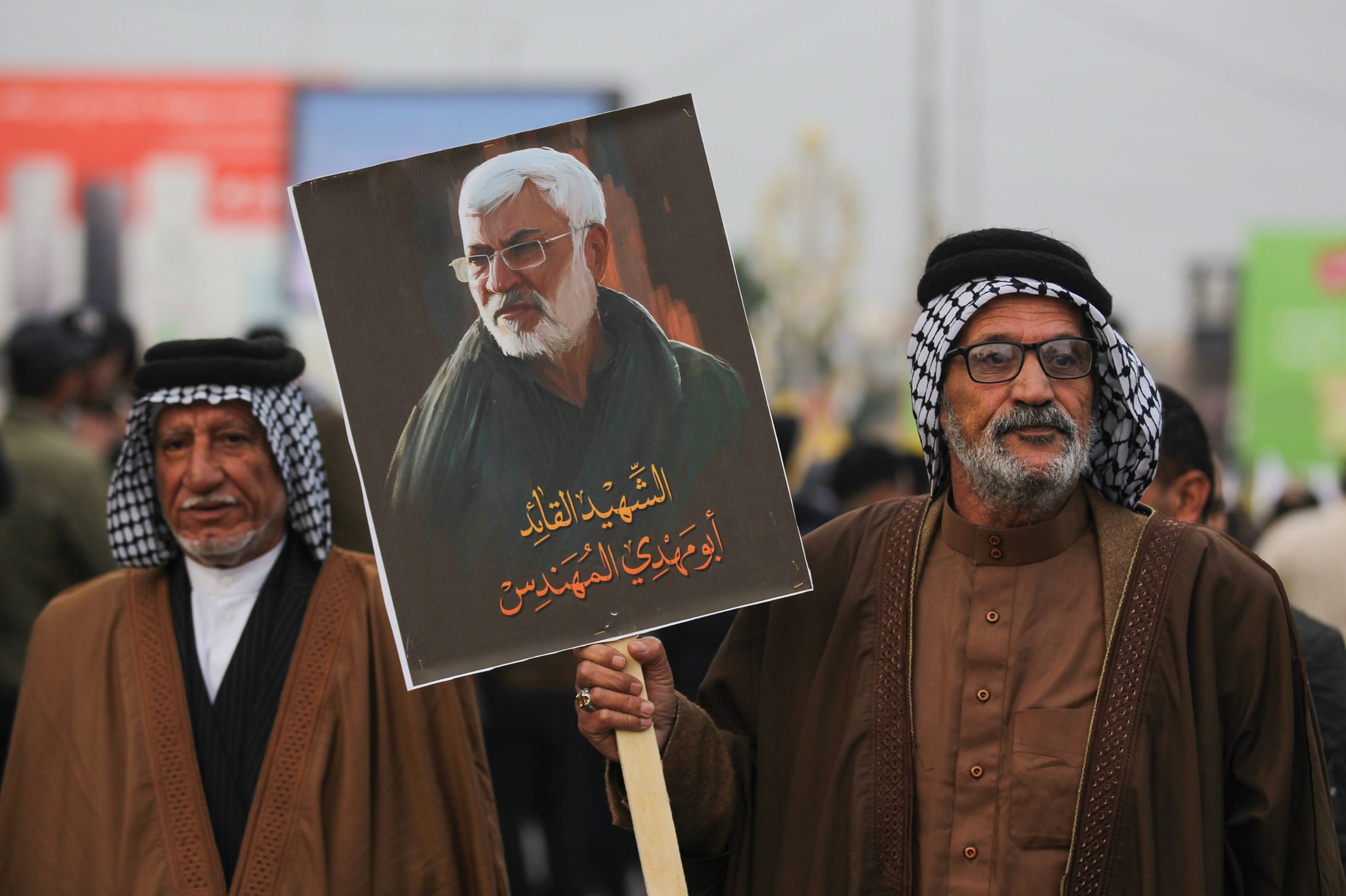 Supporters of the Hashed al-Shaabi paramilitary force and Iraq's Hezbollah brigades attend the funeral of Iranian military commander Qasem Soleimani and Iraqi paramilitary chief Abu Mahdi al-Muhandis (portrait) in Baghdad's district of al-Jadriya, in Baghdad's high-security Green Zone, on January 4, 2020. - Thousands of Iraqis chanting 