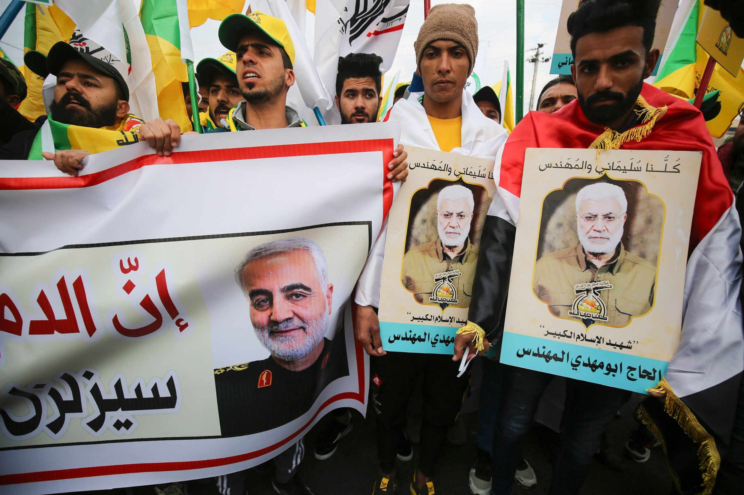 Supporters of the Hashed al-Shaabi paramilitary force and Iraq's Hezbollah brigades attend the funeral of Iranian military commander Qasem Soleimani (portrait) and Iraqi paramilitary chief Abu Mahdi al-Muhandis (portrait) in Baghdad's district of al-Jadriya, in Baghdad's high-security Green Zone, on January 4, 2020. - Thousands of Iraqis chanting 