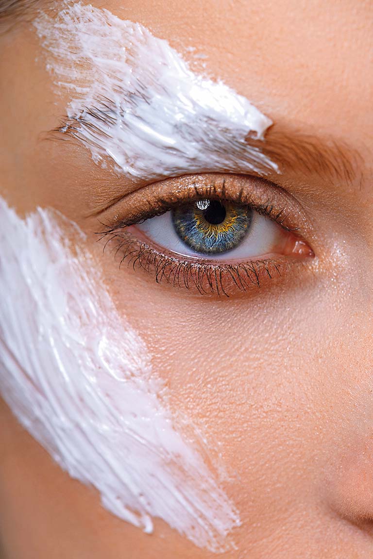 Extreme close-up of woman with cream on her face