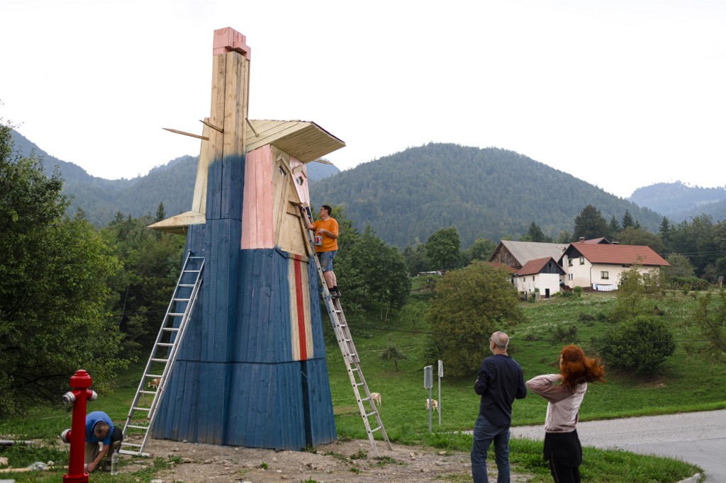 People work on a wooden statue made to resemble US President Donald Trump as they are watched by artist Tomaz Schlegl (2nd R) in the village of Sela pri Kamniku, about 20 miles northeast of Ljubljana in Slovenia, the home country of Trump's wife on August 28, 2019. - The statute which is nearly 8 meters tall has been buildt on private land and is designed by local Slovenian artist Tomaz Schlegl. (Photo by Jure Makovec / AFP) / RESTRICTED TO EDITORIAL USE - MANDATORY MENTION OF THE ARTIST UPON PUBLICATION - TO ILLUSTRATE THE EVENT AS SPECIFIED IN THE CAPTION