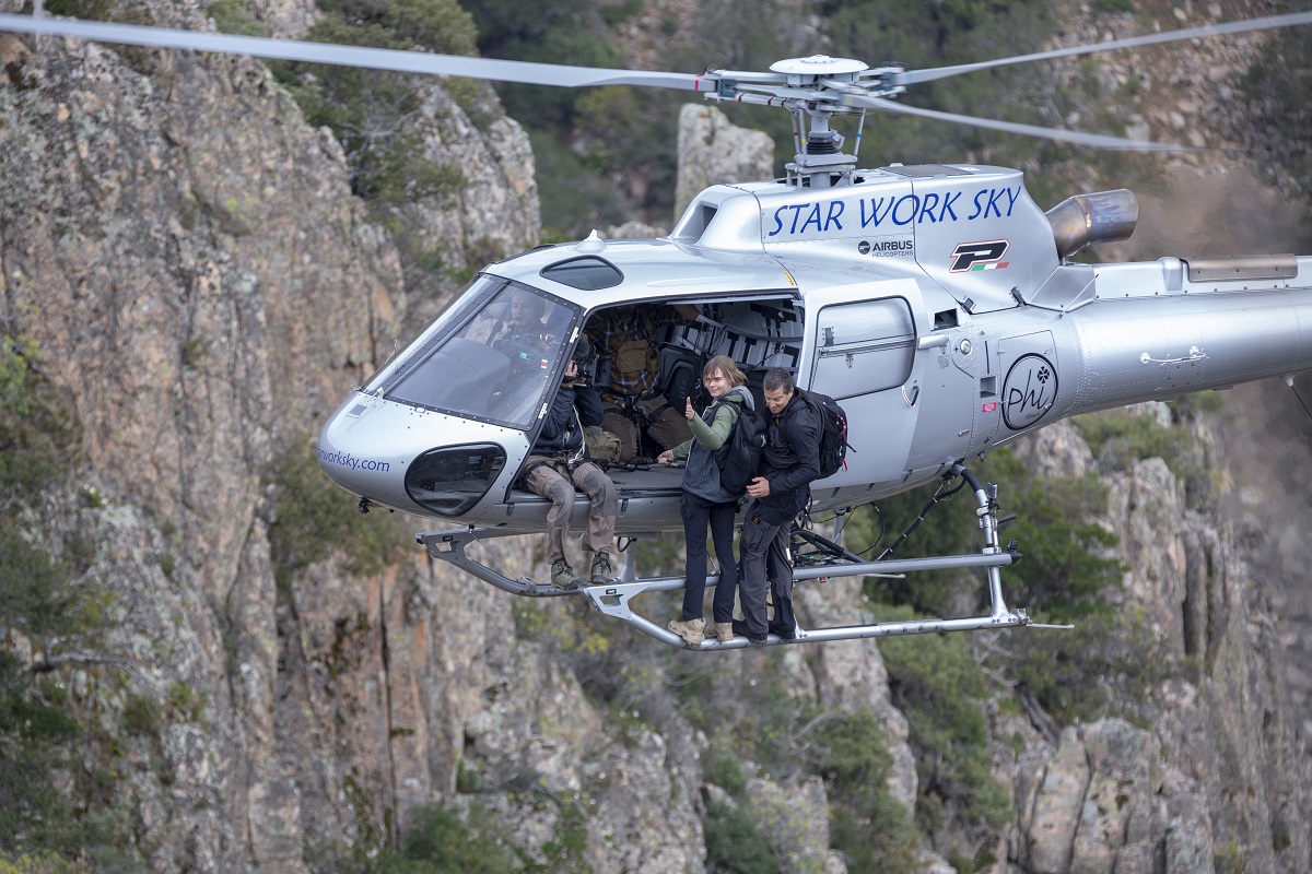 Sardinia, Italy - Cara Delevingne and Bear Gryllson the side of a helicopter for National Geographic's RUNNING WILD WITH BEAR GRYLLS. (National Geographic/Jeff Ellingson)