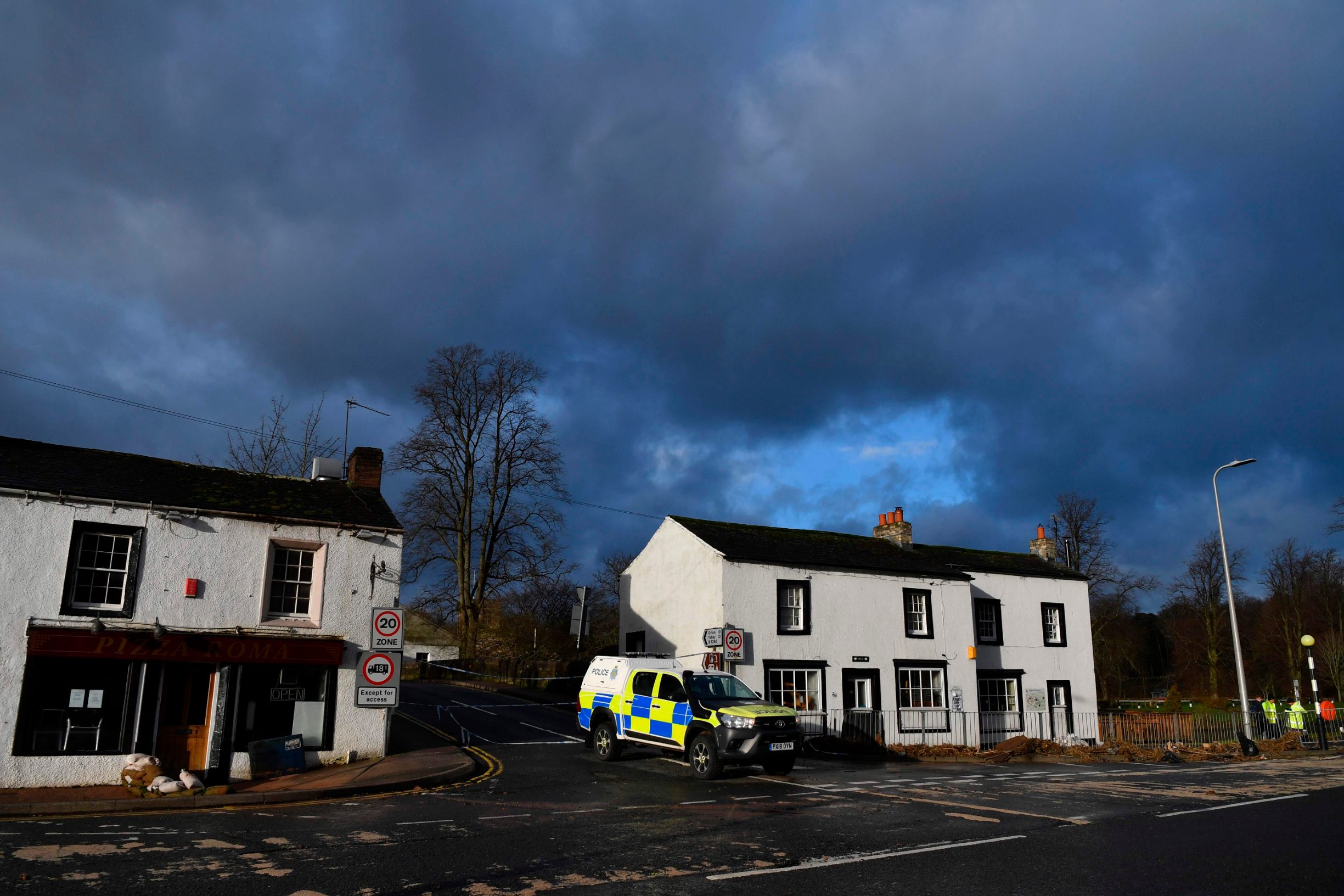 A police vehicle is positioned to block entry to a bridge for it to be checked for structural integrity in Appleby, northwest England, on February 10, 2020 after flooding brought by Storm Ciara. - Storm Ciara grounded hundreds of flights Monday and left swatches of Europe without power after unleashing torrential rain and causing flash flooding that cancelled football matches in Britain. (Photo by Paul ELLIS / AFP)