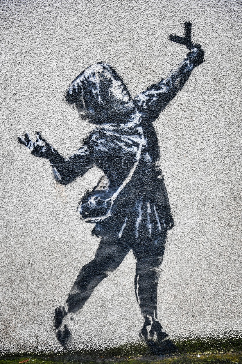 A new work of art on the side of a house on Marsh Lane, Barton Hill, Bristol, which is thought to be by street artist Banksy. The black and white stencil of a girl with a catapult and the paint splat, made of roses and plastic flowers, is in the style of Banksy, but has yet to be confirmed as being the work of the artist., Image: 498267476, License: Rights-managed, Restrictions: , Model Release: no, Credit line: Ben Birchall / PA Images / Profimedia