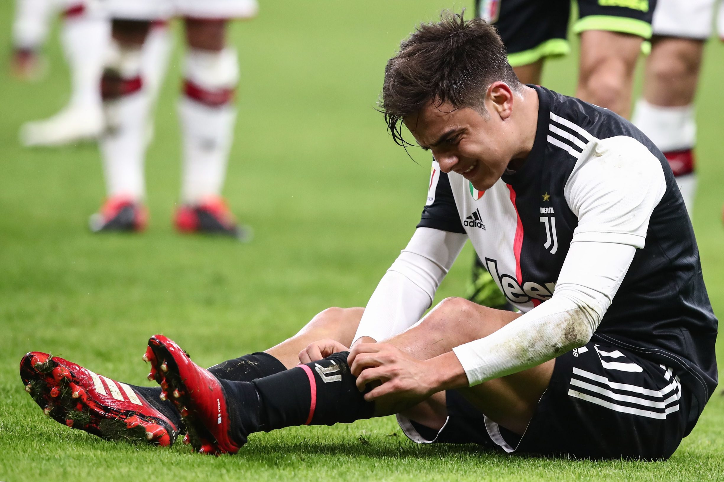 Juventus' Argentine forward Paulo Dybala checks his leg after being tackled during the Italian Cup (Coppa Italia) semi-final first leg football match AC Milan vs Juventus Turin on February 13, 2020 at the San Siro stadium in Milan. (Photo by Isabella BONOTTO / AFP)