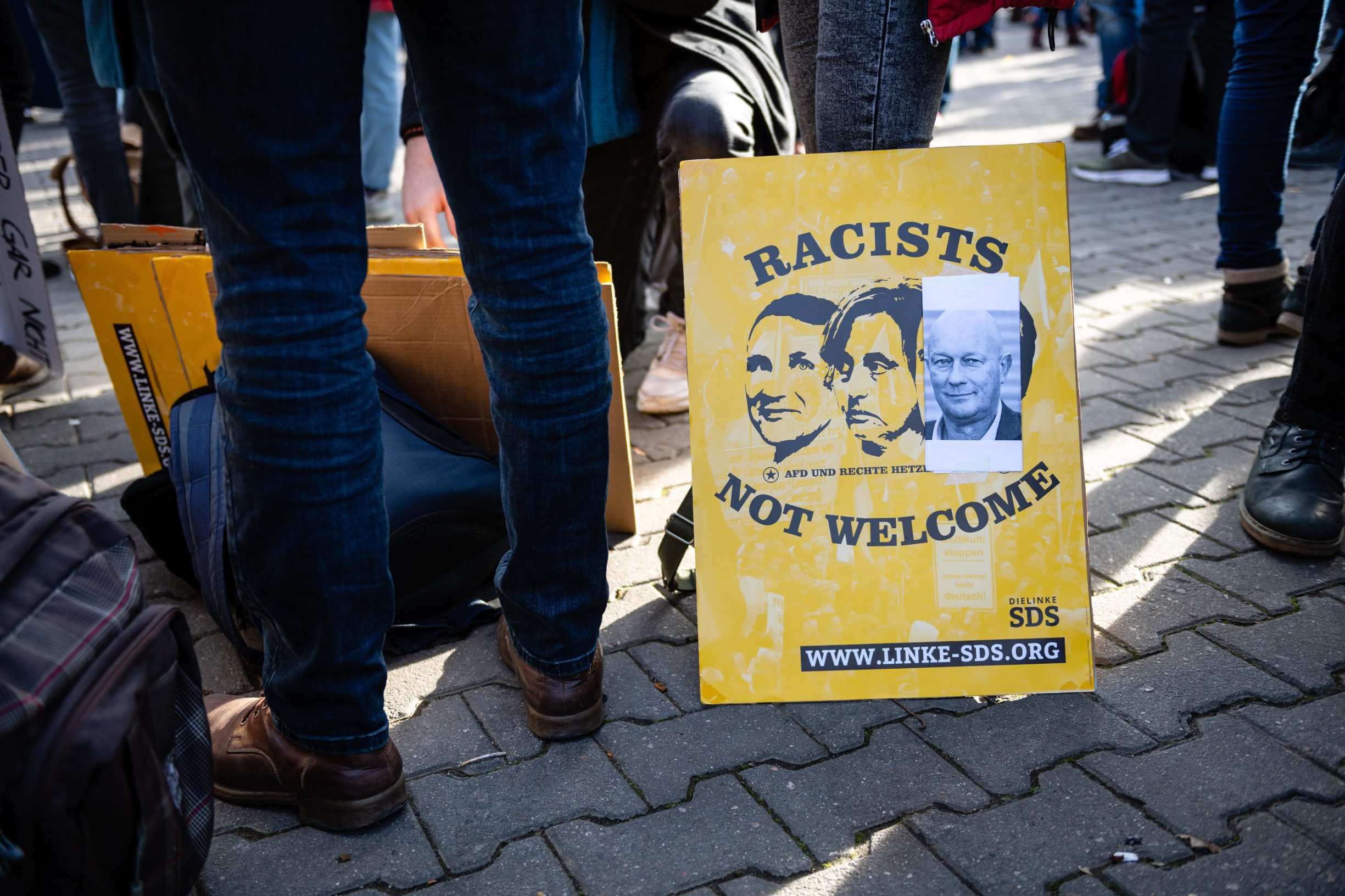 Demonstrators hold a poster showing (L-R) Afd politicians Bjoern Hoecke and Beatrix von Storch and FDP politician Thomas Kemmerich that reads 