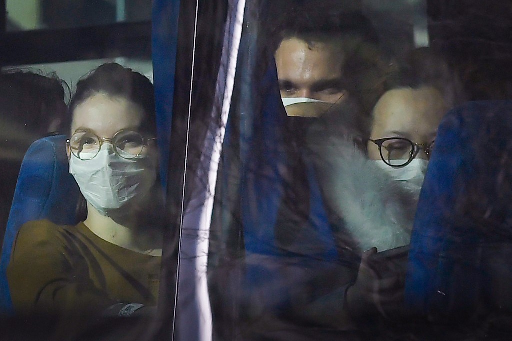 Passengers look on from a vehicle containing French citizens after their evacuation from the Chinese city of Wuhan, as it arrives at The Vacanciel Holiday Resort in Carry-le-Rouet, near Marseille, southern France on January 31, 2020, following their repatriation from the coronavirus zone. - A plane carrying around 200 French citizens evacuated from the Chinese city of Wuhan, epicentre of the coronavirus outbreak, landed near Marseille, AFP reporters onboard the aircraft said. The passengers, who will be placed in quarantine at a seaside holiday camp for two weeks, applauded as the plane touched down at the Istres military base. None have shown any symptoms of the virus that has killed 213 people and infected nearly 10,000 in mainland China, prompting the World Health Organization to declare a global emergency. (Photo by GERARD JULIEN / AFP)