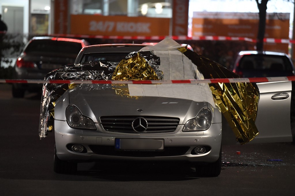 20 February 2020, Hessen, Hanau: A car is covered with thermo foil, next to the car there are glass splinters, the crime scene is sealed off with police tape. Several people have been killed by gunshots in Hanau, Hesse. Photo: Boris R�ssler/dpa