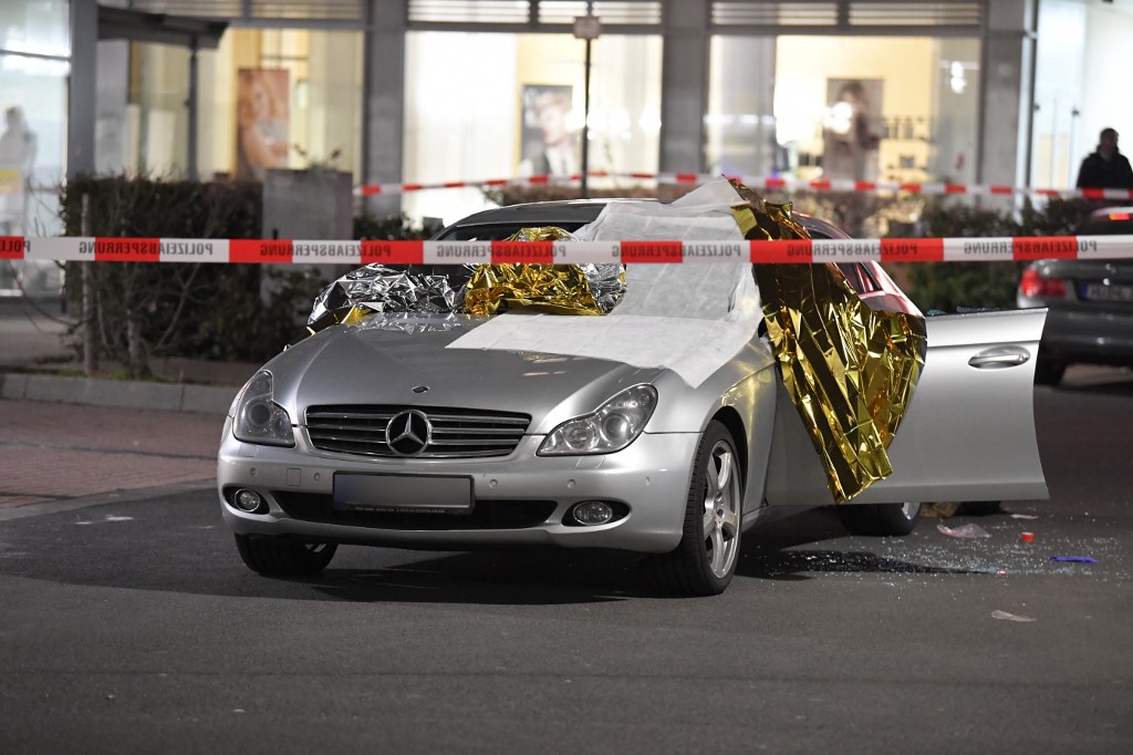20 February 2020, Hessen, Hanau: A car is covered with thermo foil, next to the car there are glass splinters, the crime scene is sealed off with police tape. Several people have been killed by gunshots in Hanau, Hesse. Photo: Boris R�ssler/dpa