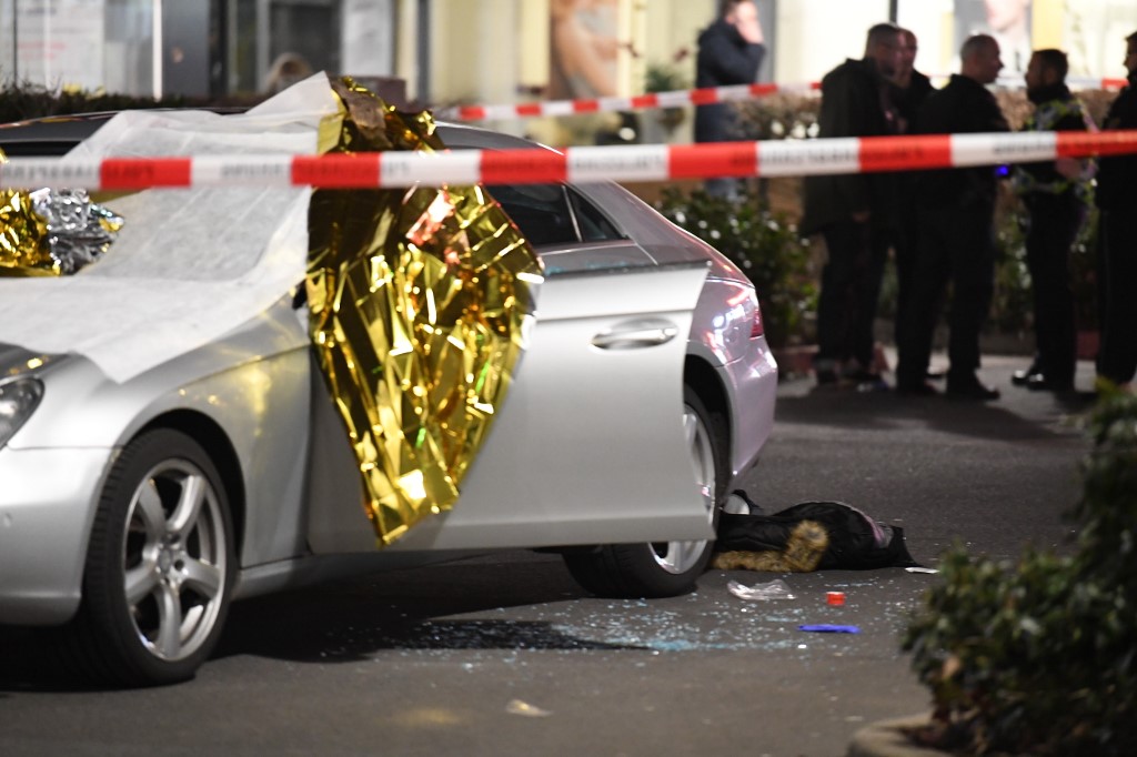 20 February 2020, Hessen, Hanau: A car is covered with thermo foil, next to the car there are glass splinters and a jacket, the crime scene is sealed off with police tape. Several people have been killed by gunshots in Hanau, Hesse. Photo: Boris R�ssler/dpa