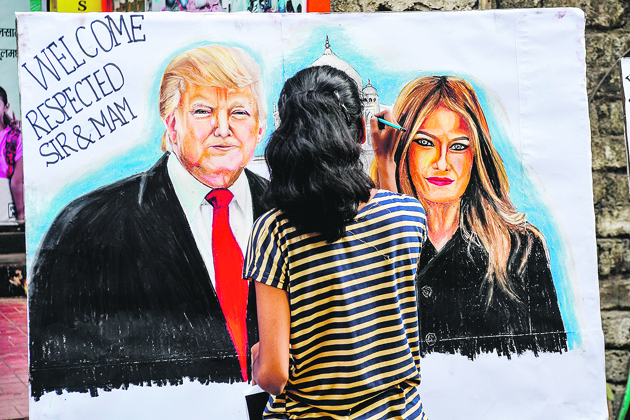 A student paints on a canva faces of US President Donald Trump (L) and his wife Melania, in the street in Mumbai on February 21, 2020, ahead of the visit of US President in India. (Photo by INDRANIL MUKHERJEE / AFP)