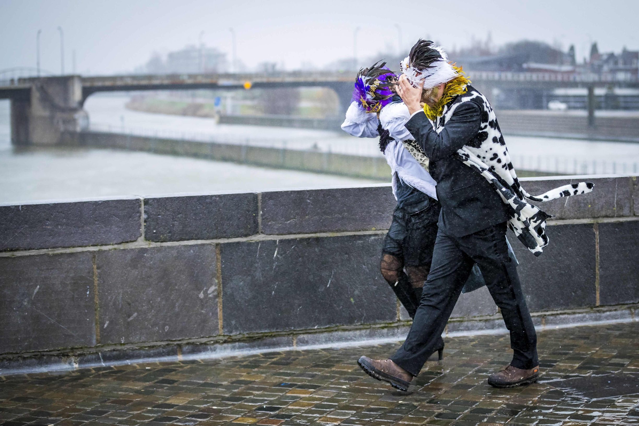 Revellers hold on to their costumes during strong winds in Maastricht, The Netherlands, on February 23, 2020. (Photo by Marcel VAN HOORN / ANP / AFP) / Netherlands OUT