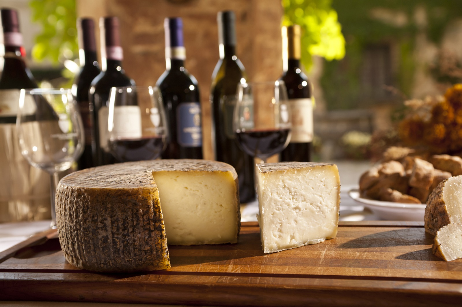 Composition of home made cheese and wine bottles from Tuscany, Italy.