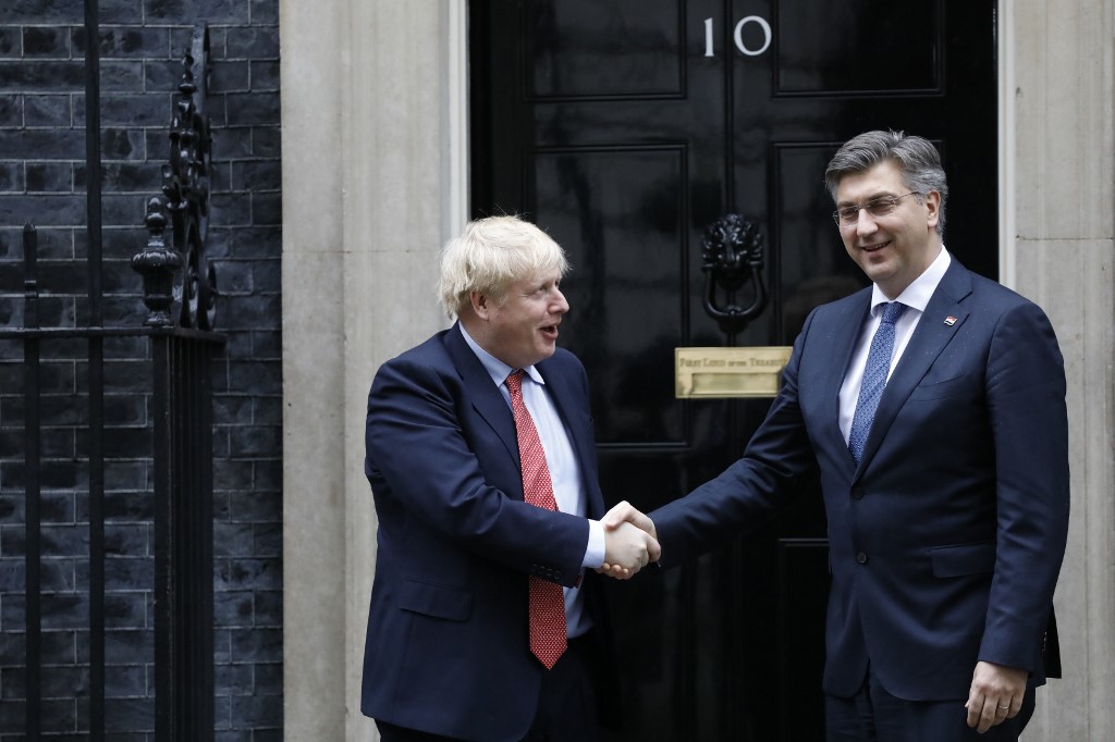 Britain's Prime Minister Boris Johnson (L) greets Croatia's Prime Minister Andrej Plenkovic (R) outside the front door of 10 Downing Street in London on February 24, 2020 ahead of a meeting. (Photo by Tolga AKMEN / AFP)