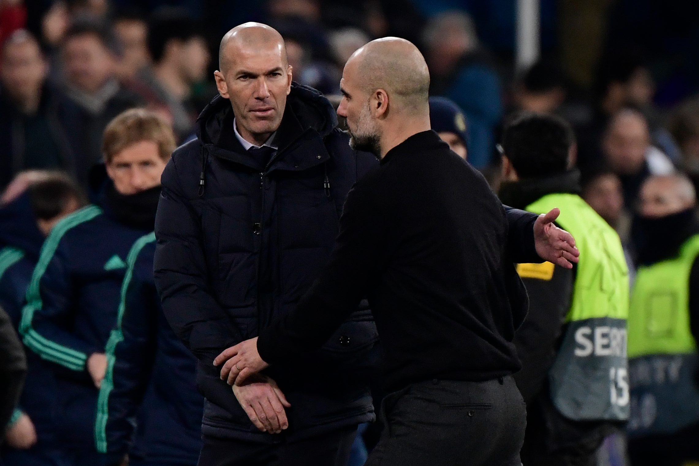 Real Madrid's French coach Zinedine Zidane (L) and Manchester City's Spanish manager Pep Guardiola greet each other at the end of the UEFA Champions League round of 16 first-leg football match between Real Madrid CF and Manchester City at the Santiago Bernabeu stadium in Madrid on February 26, 2020. (Photo by JAVIER SORIANO / AFP)