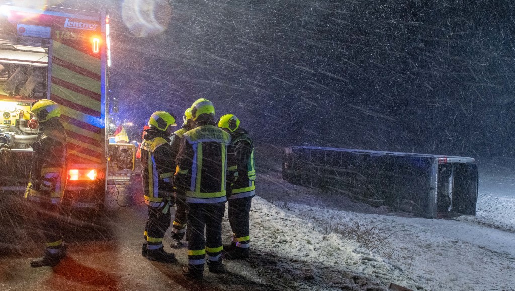 27 February 2020, Baden-Wuerttemberg, Tomerdingen: A coach lies fallen over in a field next to the B10. With snow-smooth road and strong wind the bus came off the road. Eight inmates were slightly injured. Photo: Stefan Puchner/dpa