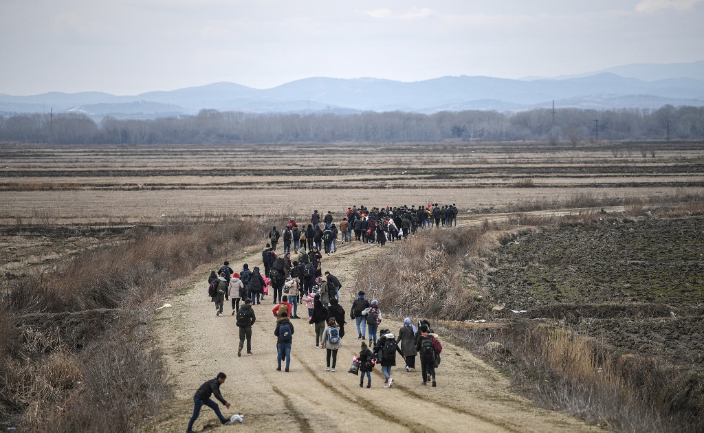 Afghan refugees walk towards Turkey-Greece border at Ipsala district in Edirne Province in northwestern Turkey, on February 28 , 2020. - Turkey will no longer close its border gates to refugees who want to go to Europe , a senior official told AFP on February 28, shortly after the killing of 33 Turkish soldiers in an airstrike in northern Syria. (Photo by Ozan KOSE / AFP)