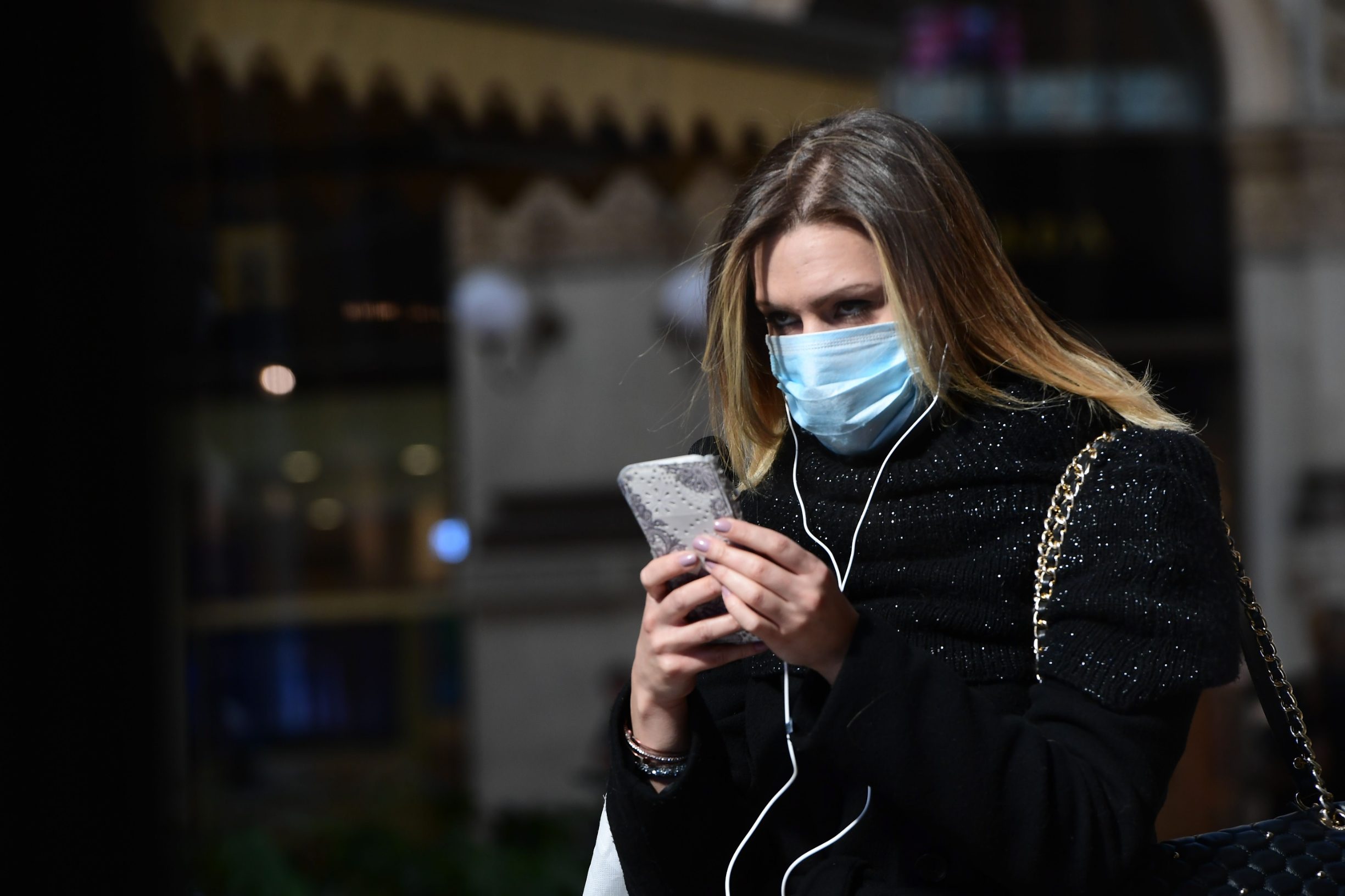 A woman wearing a protective mask walk in Galleria Vittorio Emanuele II in center Milan on February 28, 2020. - Italy urged tourists spooked by the novel coronavirus COVID-19 not to stay away, but efforts to reassure the world it was managing the outbreak were overshadowed by confusion over case numbers. (Photo by Miguel MEDINA / AFP)
