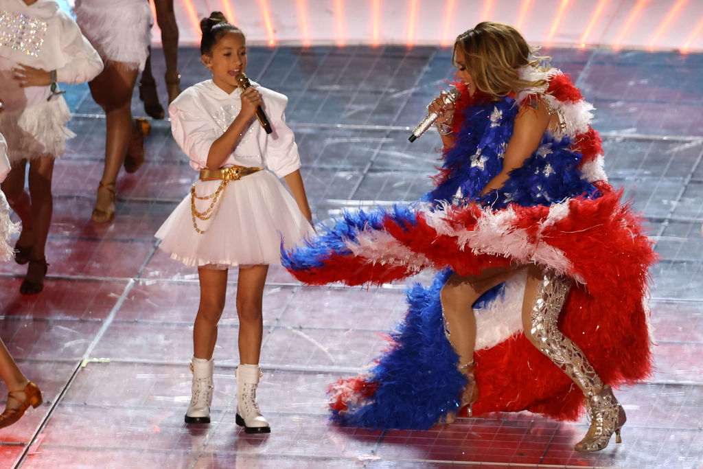MIAMI, FLORIDA - FEBRUARY 02: Singer Jennifer Lopez and her daughter Emme Maribel Muñiz perform while a Puerto Rican flag is displayed on stage during the Pepsi Super Bowl LIV Halftime Show at Hard Rock Stadium on February 02, 2020 in Miami, Florida. (Photo by Elsa/Getty Images)