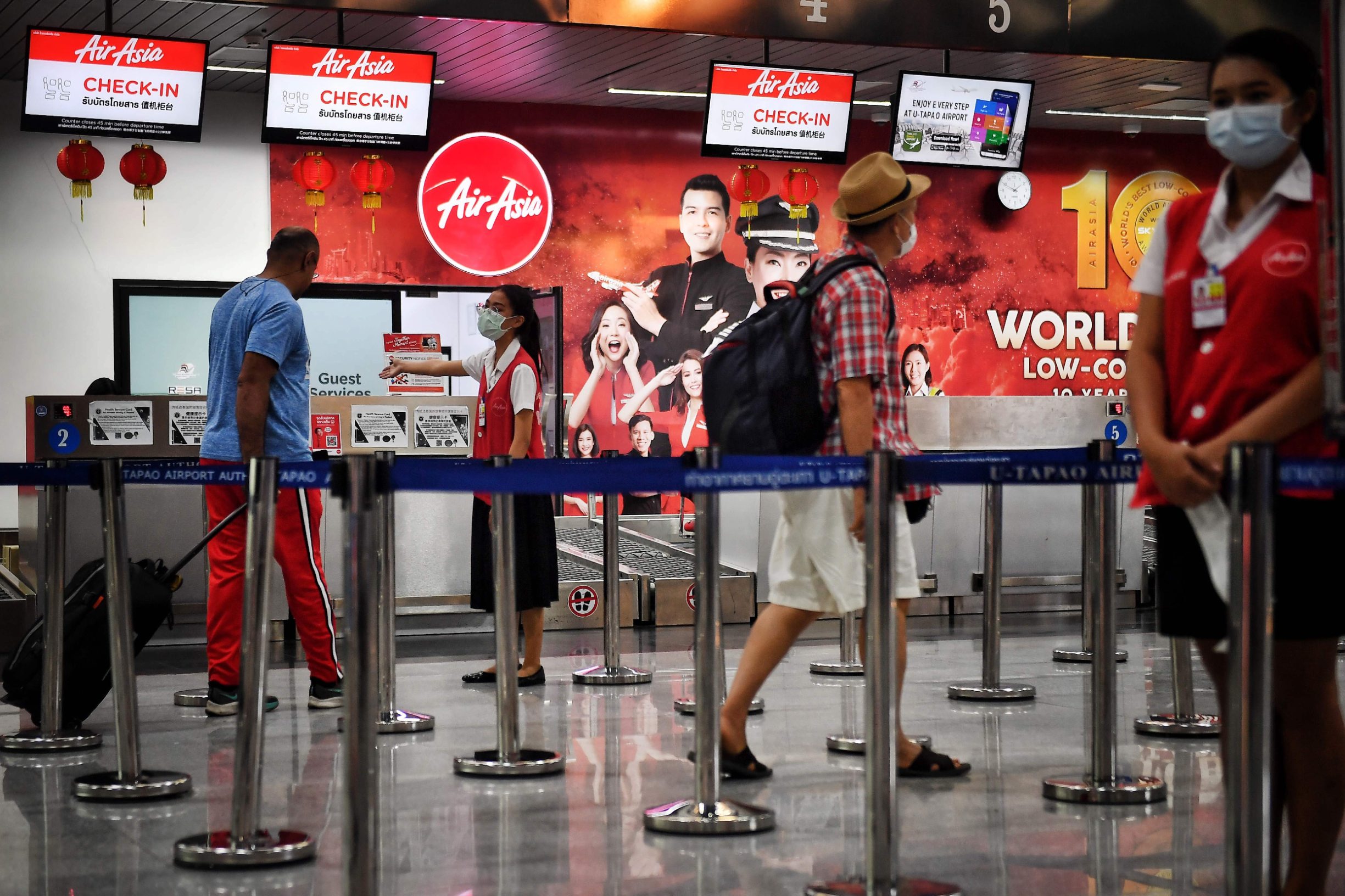 Passengers check in to an AirAsia flight at U-Tapao Airport in Rayong on February 4, 2020, where Thais nationals who had been evacuated from Wuhan, the epicentre of the novel coronavirus outbreak, are expected to arrive. (Photo by Lillian SUWANRUMPHA / AFP)