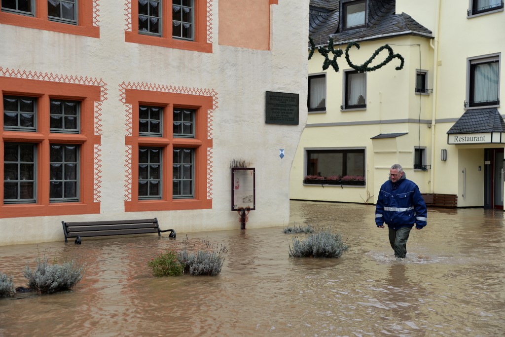 04 February 2020, Rhineland-Palatinate, Bernkastel-Kues: Local resident Dennis Pr�m walks along the B53 in Bernkastel-Kues, which is flooded by the Moselle and is up to the houses. Numerous roads along the river are flooded in sections and closed to traffic. Photo: Harald Tittel/dpa