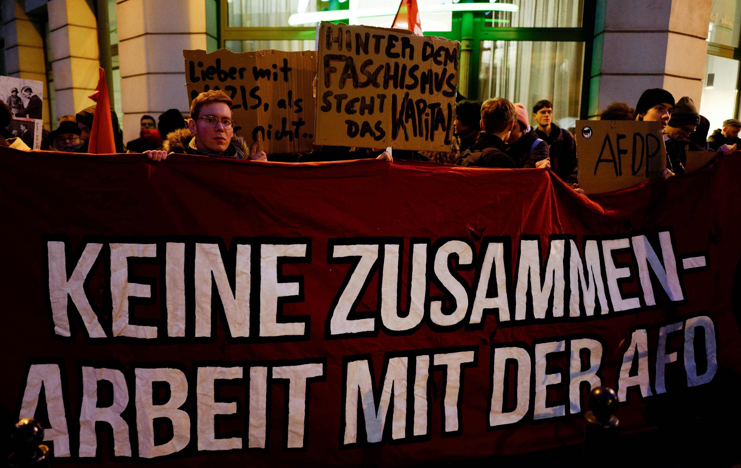 A protestor holds up a banner which reads 