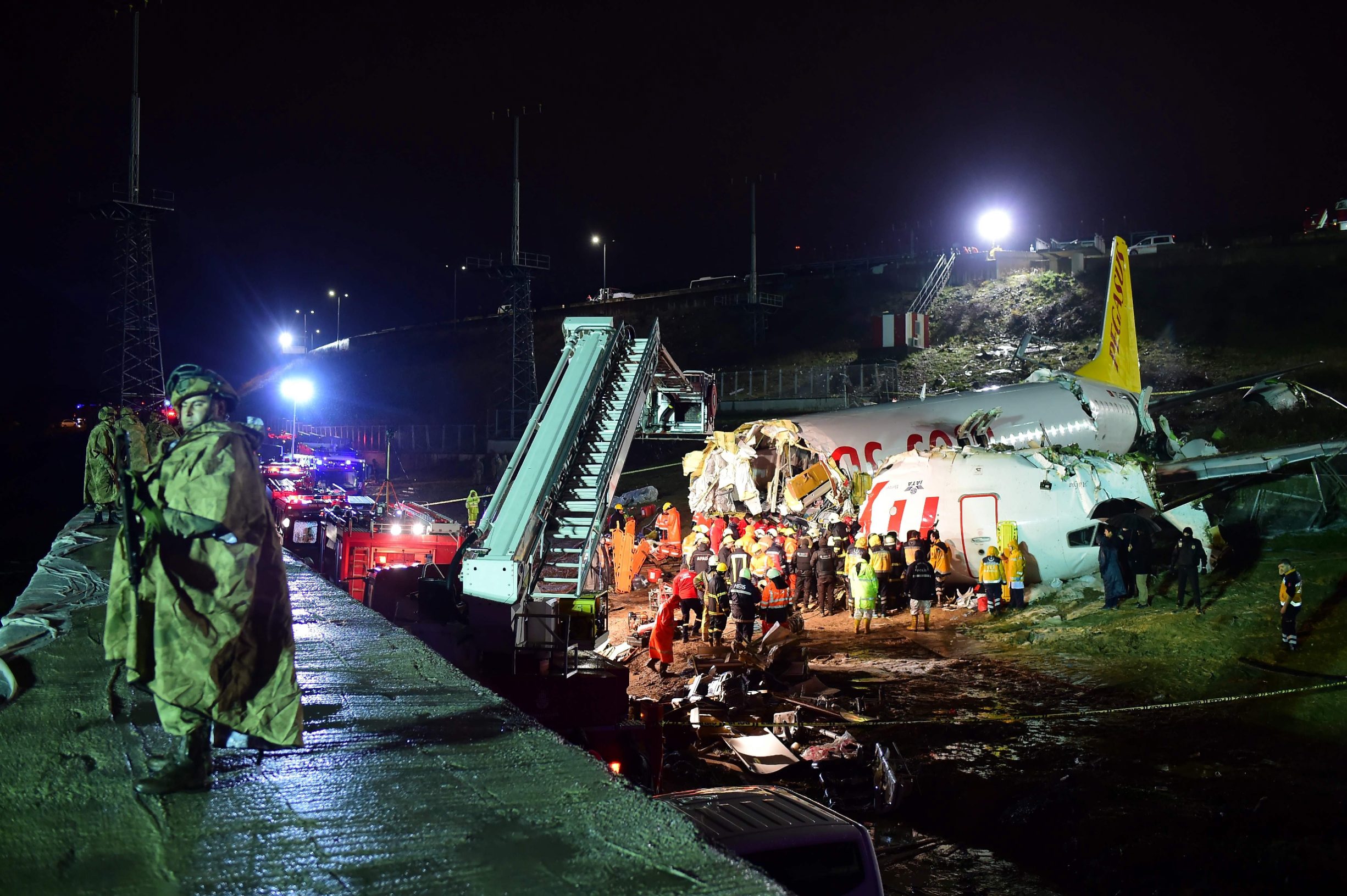 Rescuers work to extract passengers from the crash of a Pegasus Airlines Boeing 737 airplane, after it skidded off the runway upon landing at Sabiha Gokcen airport in Istanbul on February 5, 2020. - The plane carrying 171 passengers from the Aegean port city of Izmir split into three after landing in rough weather. Officials said no-one had lost their lives in the accident, but dozens of people were injured. (Photo by Yasin AKGUL / AFP)