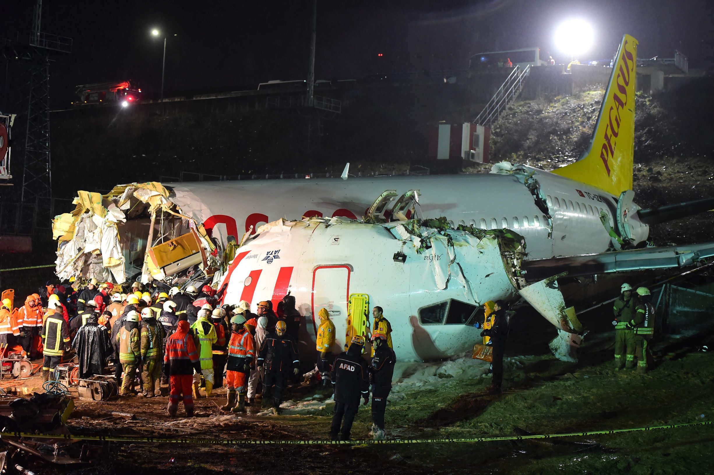 Rescuers work to extract passengers from the crash of a Pegasus Airlines Boeing 737 airplane, after it skidded off the runway upon landing at Sabiha Gokcen airport in Istanbul on February 5, 2020. - The plane carrying 171 passengers from the Aegean port city of Izmir split into three after landing in rough weather. Officials said no-one had lost their lives in the accident, but dozens of people were injured. (Photo by Yasin AKGUL / AFP)
