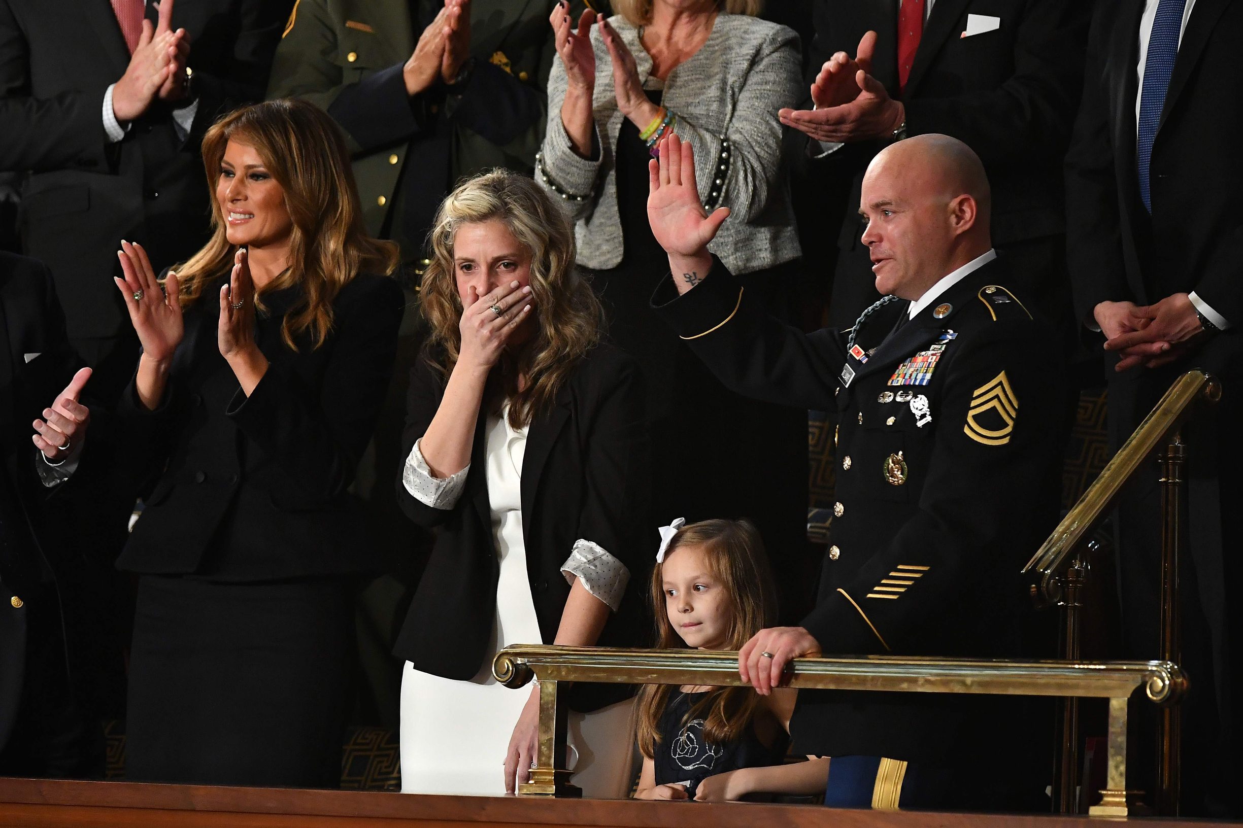 Sgt Townsend Williams (R) waves next to his children after returning from deployment in Afghanistan as his wife Amy (2L) looks on during the State of the Union address at the US Capitol in Washington, DC, on February 4, 2020. (Photo by MANDEL NGAN / AFP)
