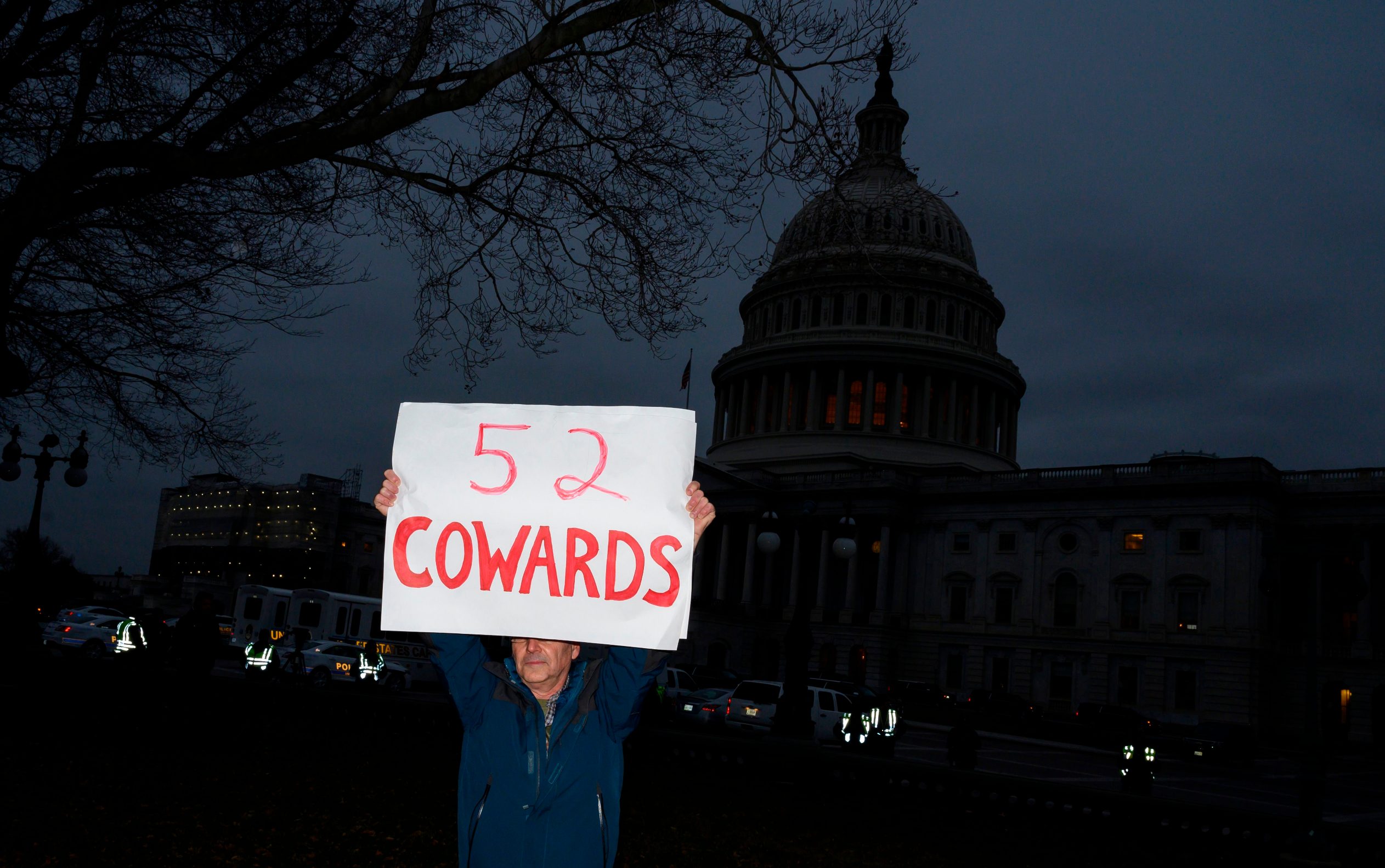 A protester holds up a sign outside the Capitol in Washington, DC, on February 5, 2020, after the US Senate acquited the US president in his impeachment trial. - The US Senate acquitted President Donald Trump of abuse of power and obstruction of Congress following a historic two-week trial. (Photo by Andrew CABALLERO-REYNOLDS / AFP)