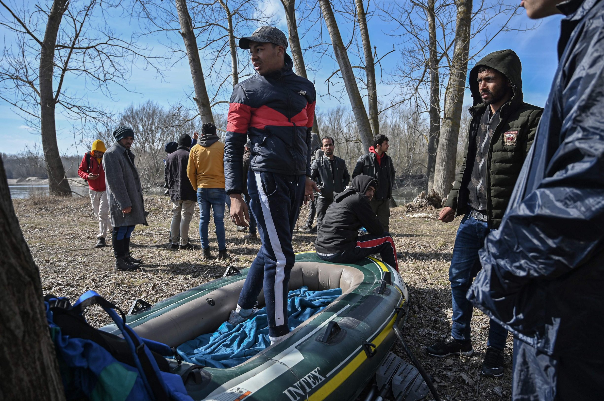 Migrants prepare a boat before an attempt to cross the Meritsa river to enter Greece, near Edirne, Turkey, on March 1, 2020. - Thousands more migrants reached the Turkish border with Greece on March 1, 2020, AFP journalists said, after President threatened to let them cross into Europe. At least 2,000 people including women and children arrived on the morning from Istanbul and walked through a field towards the Pazarkule border gate, a correspondent said. The group included Afghans, Syrians and Iraqis. (Photo by Ozan KOSE / AFP)