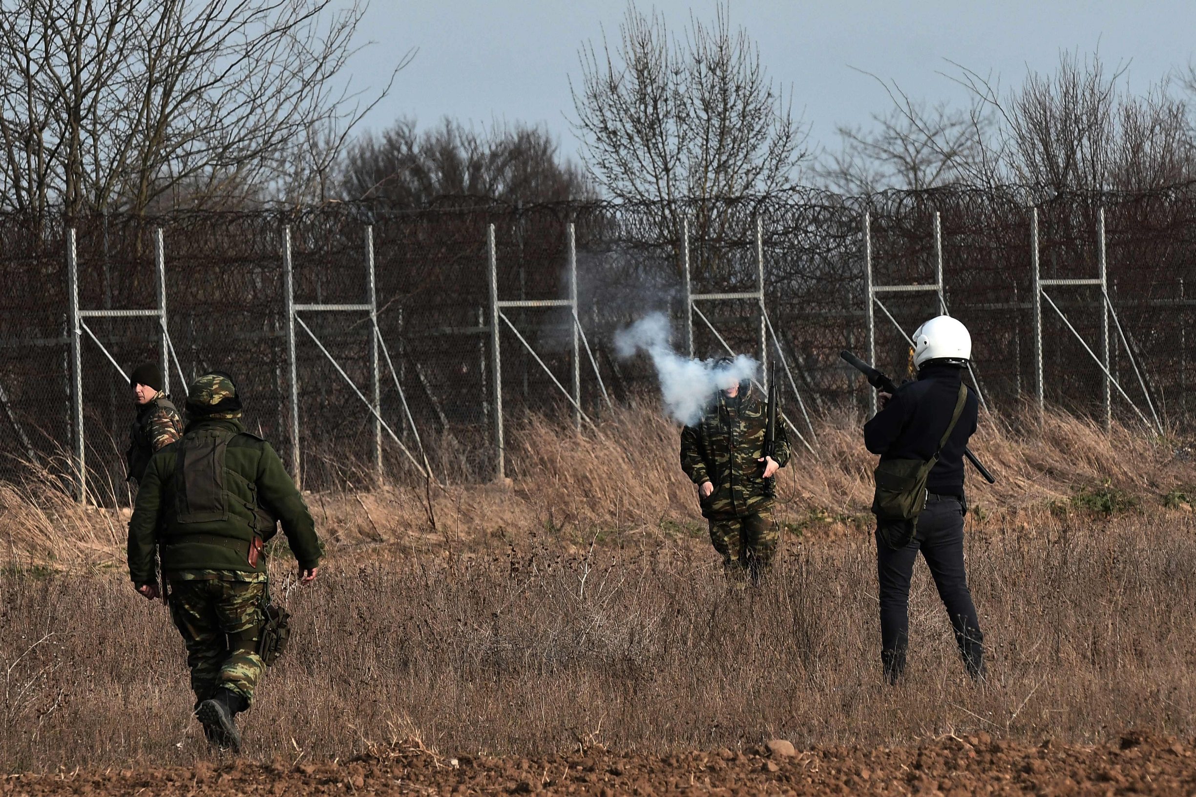 A Greek riot police officer lobs a tear gas canister during clashes with migrants along the Greece-Turkey border in the village of Kastanies on March 1, 2020. - Thousands more migrants reached the Turkish border with Greece on March 1, 2020, AFP journalists said, after the Turkish President threatened to let them cross into Europe. At least 2,000 people including women and children arrived on the morning from Istanbul and walked through a field towards the Pazarkule border gate, a correspondent said. The group included Afghans, Syrians and Iraqis. (Photo by Sakis MITROLIDIS / AFP)