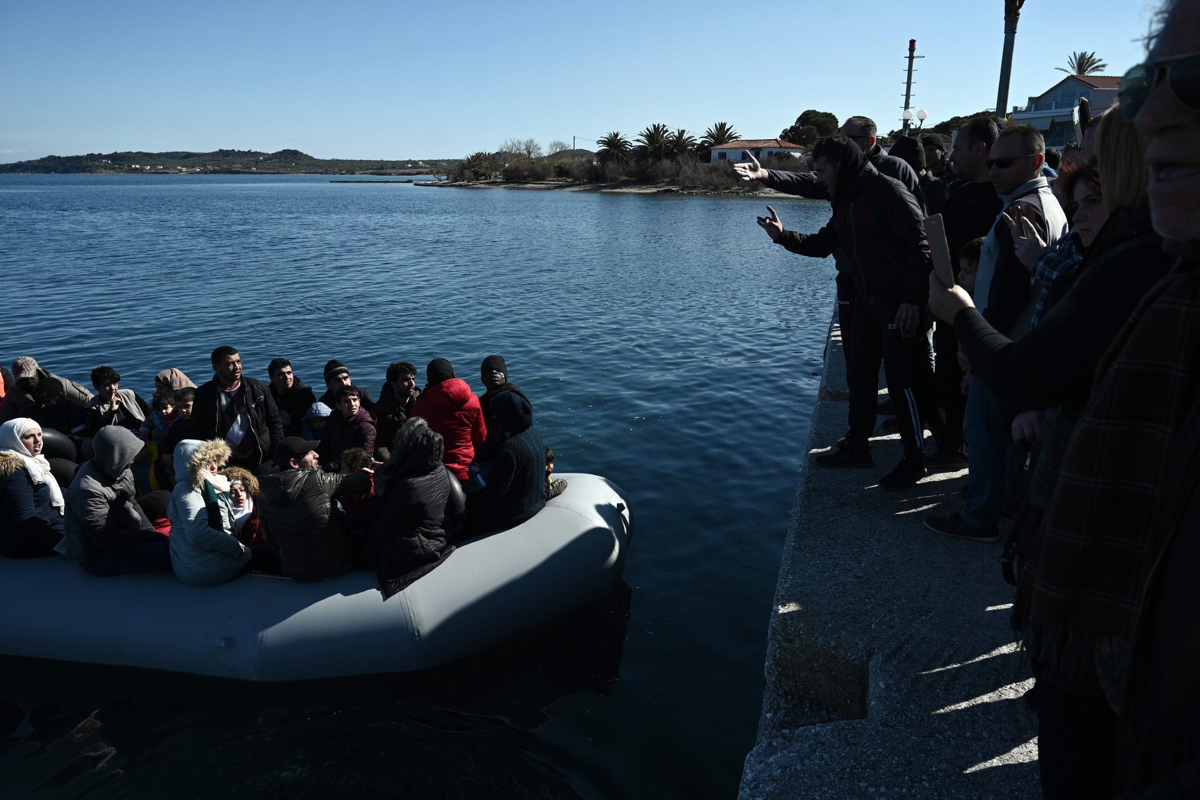 TOPSHOT - Migrants are seen on an inflatable boat as local residents prevent them from disembarking in Lesbos island, on March 1, 2020. - Greece said Sunday it has blocked nearly 10,000 migrants at its border with Turkey, which opened its gates to Europe as tensions mount over its deepening conflict in Syria. 
Migrant numbers have swelled along the rugged frontier after Turkey's president Recep Tayyip Erdogan said it 