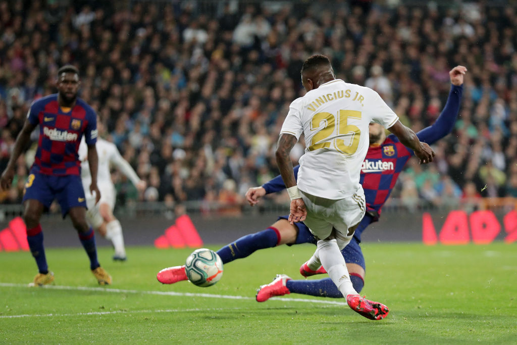 MADRID, SPAIN - MARCH 01: Vinicius Junior of Real Madrid scores his team's first goal past Gerard Pique of FC Barcelona during the Liga match between Real Madrid CF and FC Barcelona at Estadio Santiago Bernabeu on March 01, 2020 in Madrid, Spain. (Photo by Gonzalo Arroyo Moreno/Getty Images)