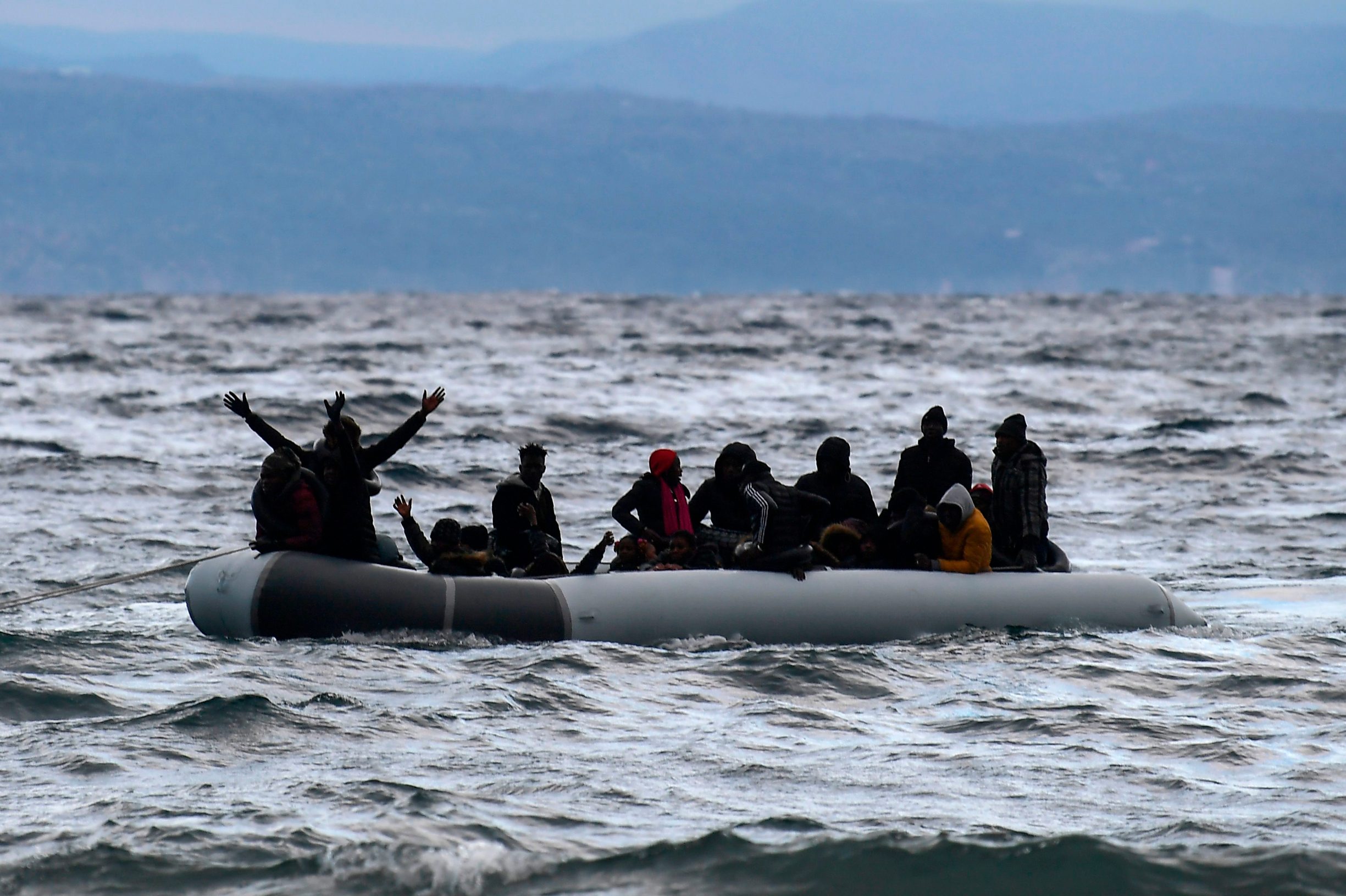TOPSHOT - A dinghy transporting 27 refugees and migrants originating from Gambia and the Republic of Congo is pulled towards Lesbos island after being rescued by a war ship during their sea crossing between Turkey and Greece on February 29, 2020. - Greece blocked hundreds of migrants trying to enter the country on Friday after Turkey said it would open the gates for refugees from Syria to enter the European Union. Turkey's threat came hours after a Syrian strike on Thursday killed 33 of its soldiers in Idlib and was aimed at forcing European governments to do more to support it in its fight against the regime. (Photo by ARIS MESSINIS / AFP)