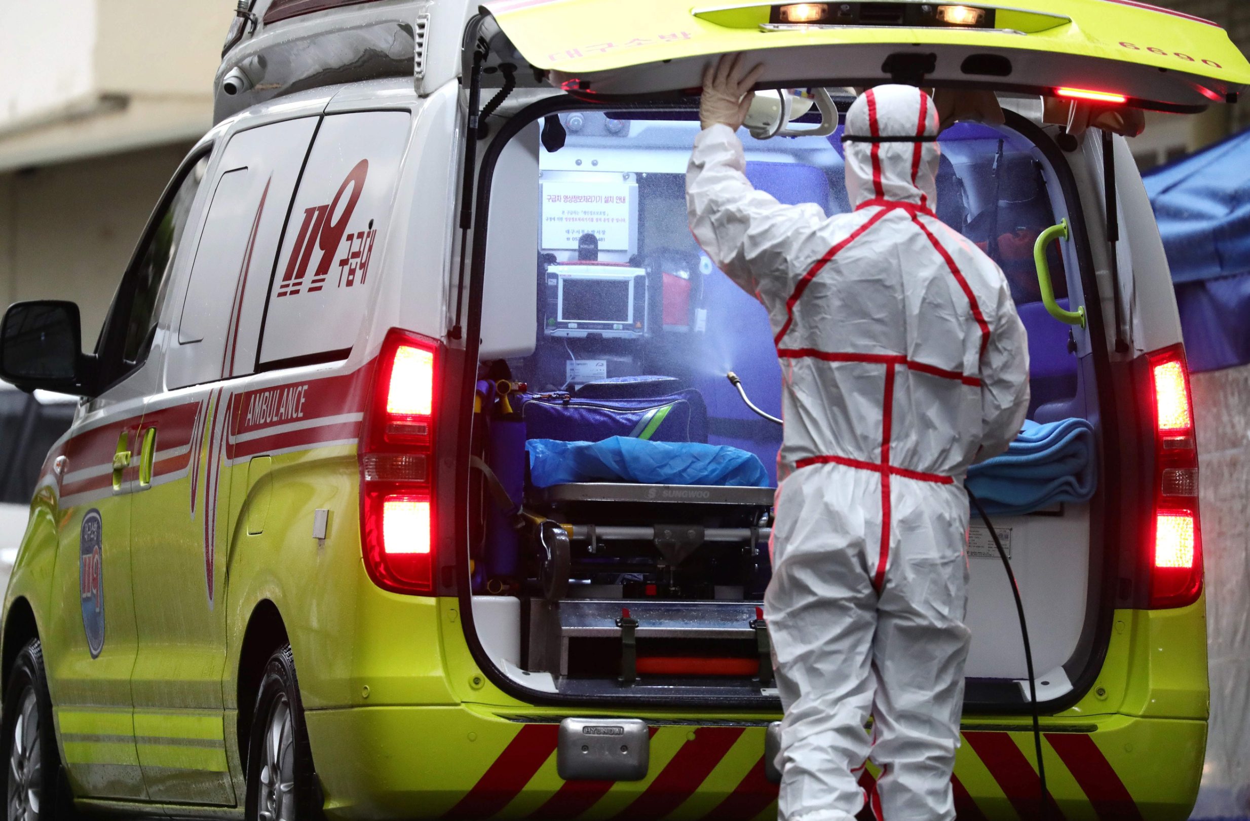 A medical worker sprays disinfectant into an ambulance at a hospital where patients infected with the COVID-19 coronavirus are being treated, in the southeastern city of Daegu on February 25, 2020. - The novel coronavirus outbreak in South Korea is 
